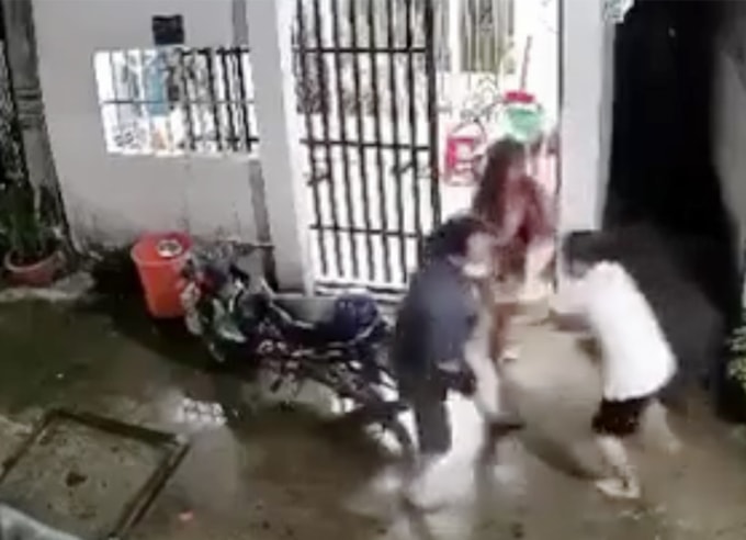 Quang (áo tối màu, bên trái) ẩu đả với vợ chồng nạn nhân. Ảnh cắt từ camera an ninh