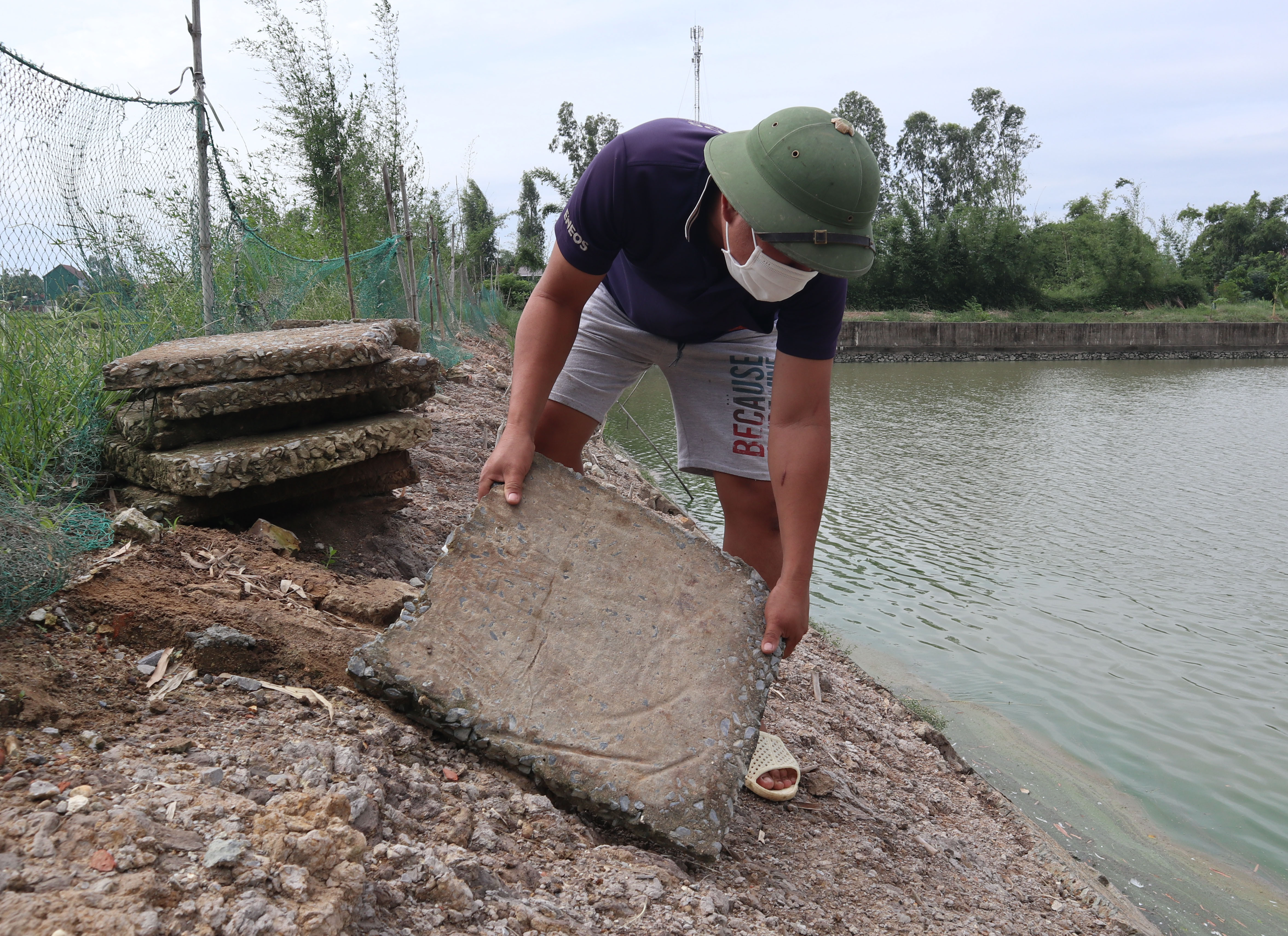 Trước khi bão về, anh Nguyễn Văn Điệp dùng bê tông kè ao tránh sạt lở, gây thất thoát cá. Ảnh: Thanh Phúc