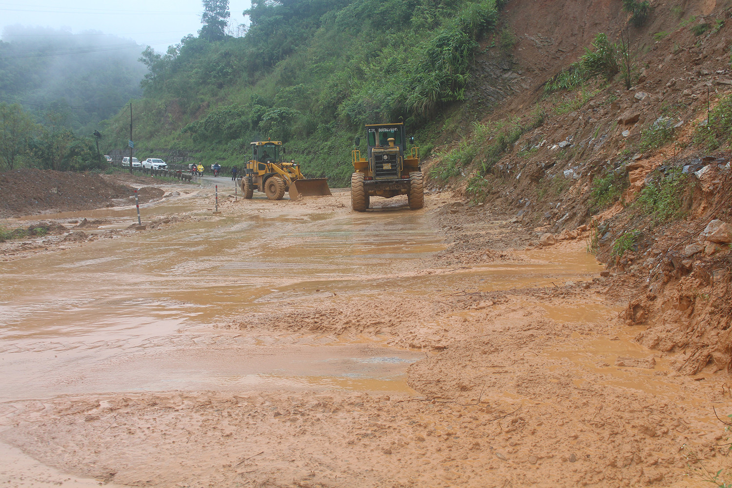 Huyện Con Cuông đã huy động 2 máy xúc để san gạt đất đá trên tuyến đường này. Ảnh: Bảo Hân