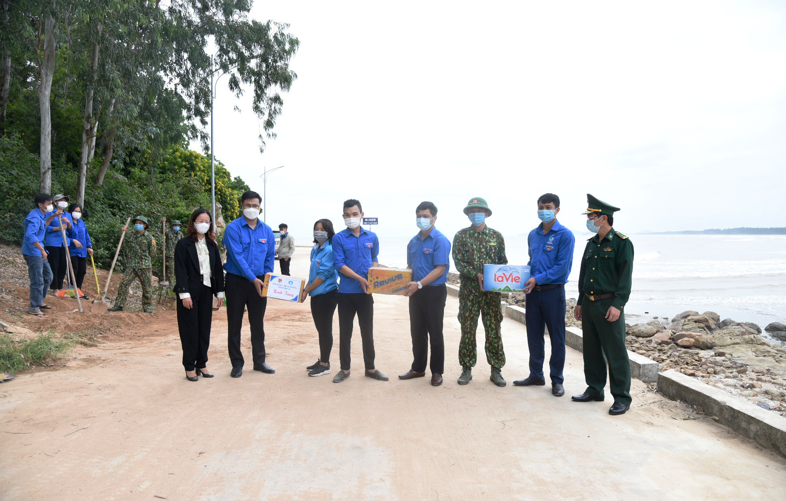 Lãnh đạo Tỉnh đoàn tặng quà động viên đội đoàn viên thanh niên vệ sinh môi trường biển tại phường Quỳnh Phương. Ảnh: TG