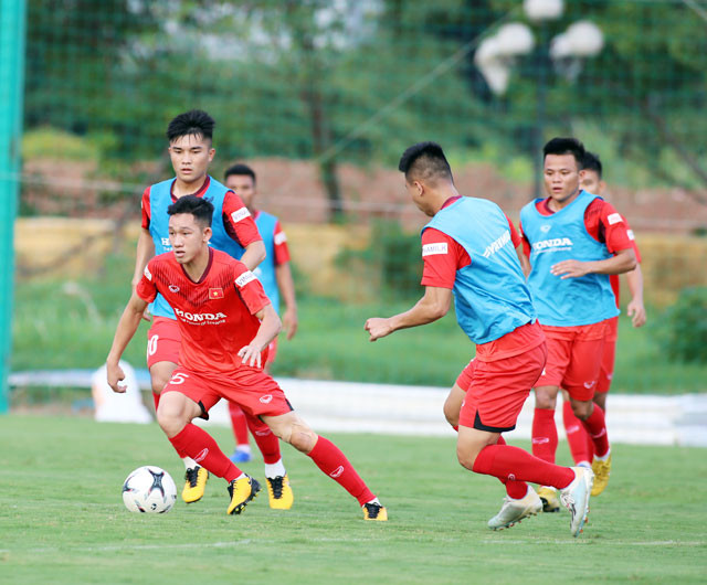 Hai Long (bìa trái) nỗ lực đi bóng trong một buổi tập.