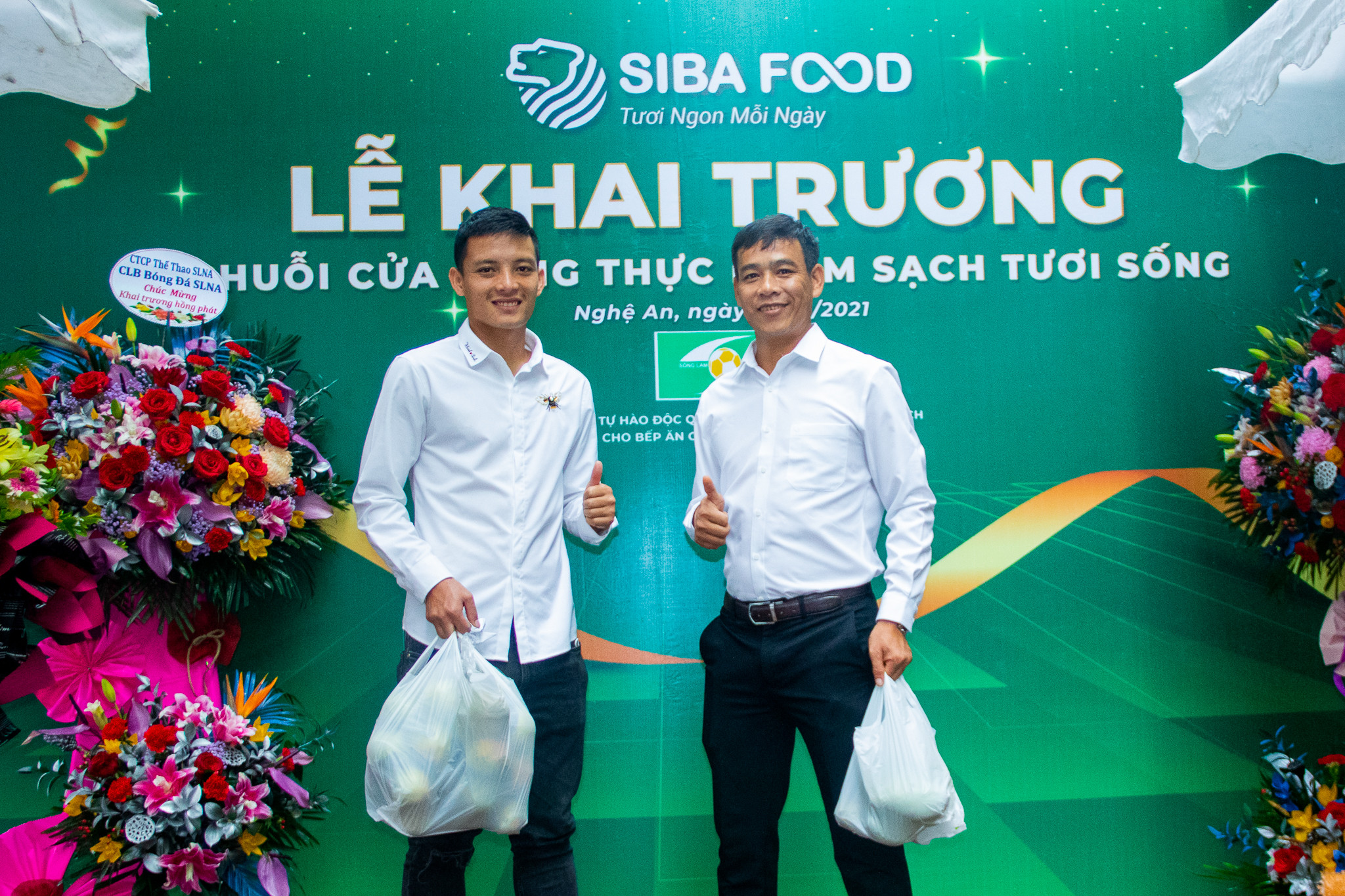 HLV trưởng Nguyễn Huy Hoàng và đội trưởng Hoàng Văn Khánh bảnh bao dự sự kiện nhưng không quên mua thực phẩm về cho gia đình. Ảnh: PV
