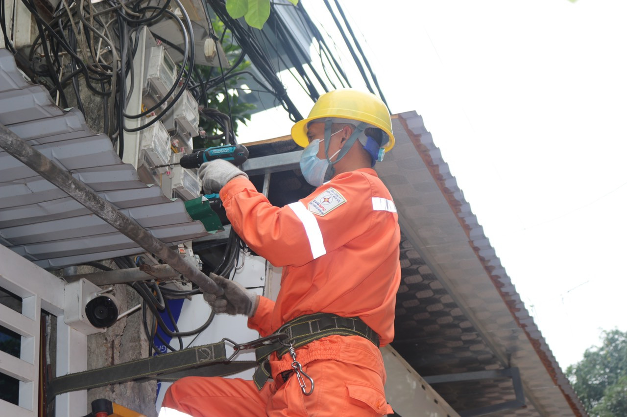 Công nhân Điện lực TP Vinh thay công tơ cơ khí sang công tơ điện tử nâng cao dịch vụ  khách hàng Ảnh: Phan Thủy