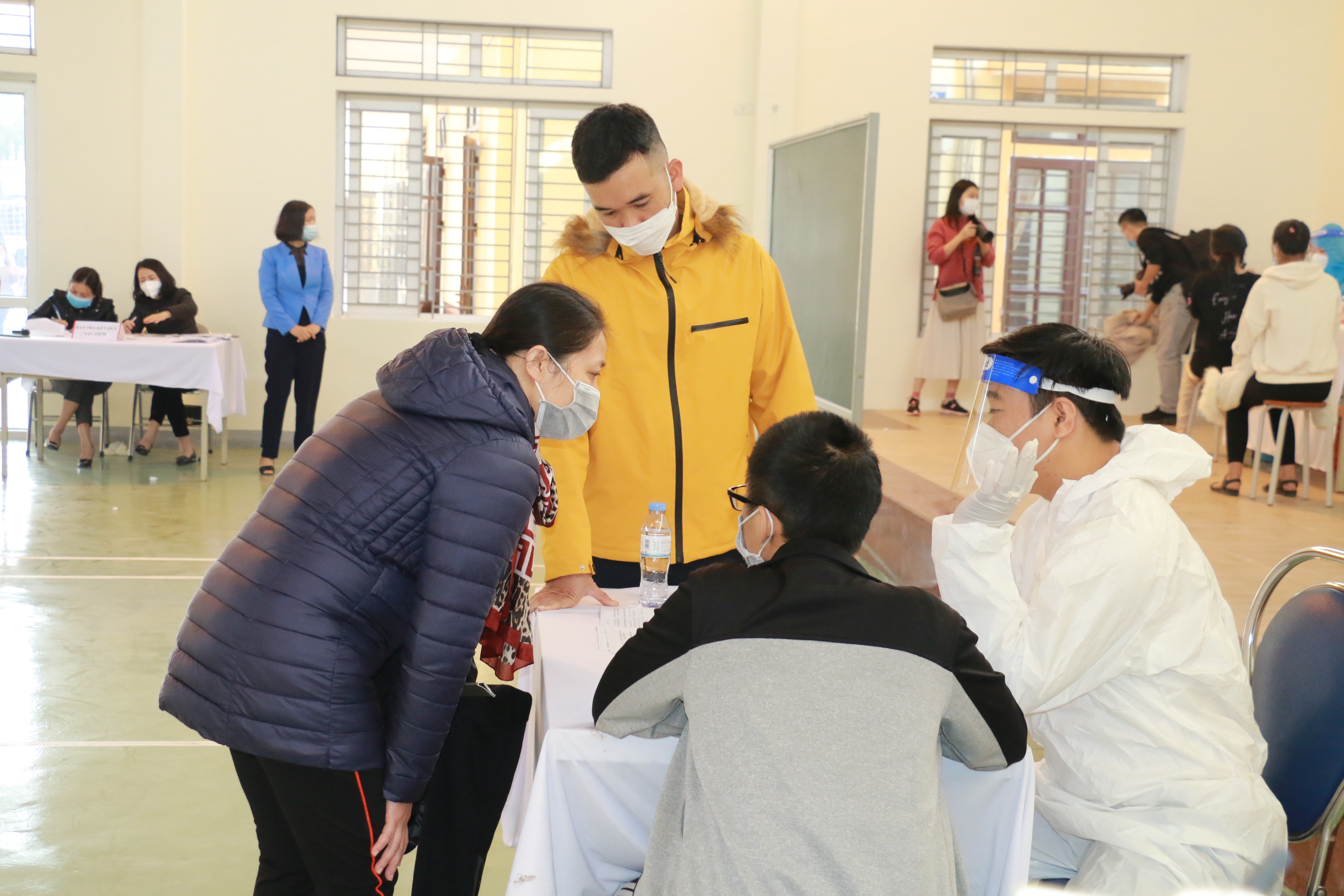 Một phụ huynh ở phường Bến Thủy vào tận điểm tiêm để trao đổi với bác sỹ về tình hình sức khỏe của con. Ảnh: Mỹ Hà
