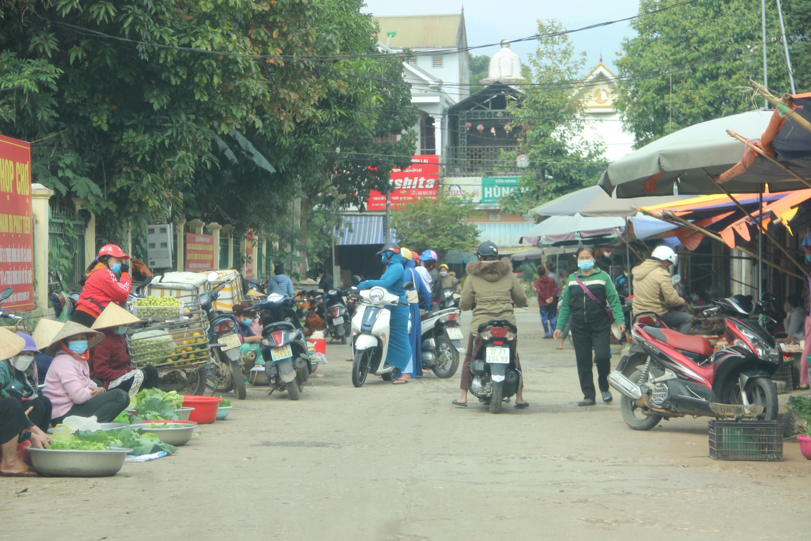 Người dân đứng giữa lòng đường mua bán gây ách tắc giao thông. Ảnh: Tiến Đông 