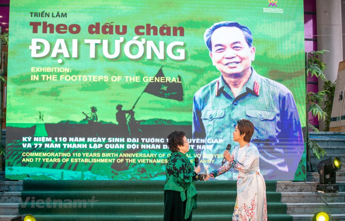 Nhà thơ Nguyễn Thị Mỹ Dung (trái) và ca sỹ Mỹ Linh ngẫu hứng trong lễ khai mạc triển lãm. Ảnh: Minh Sơn