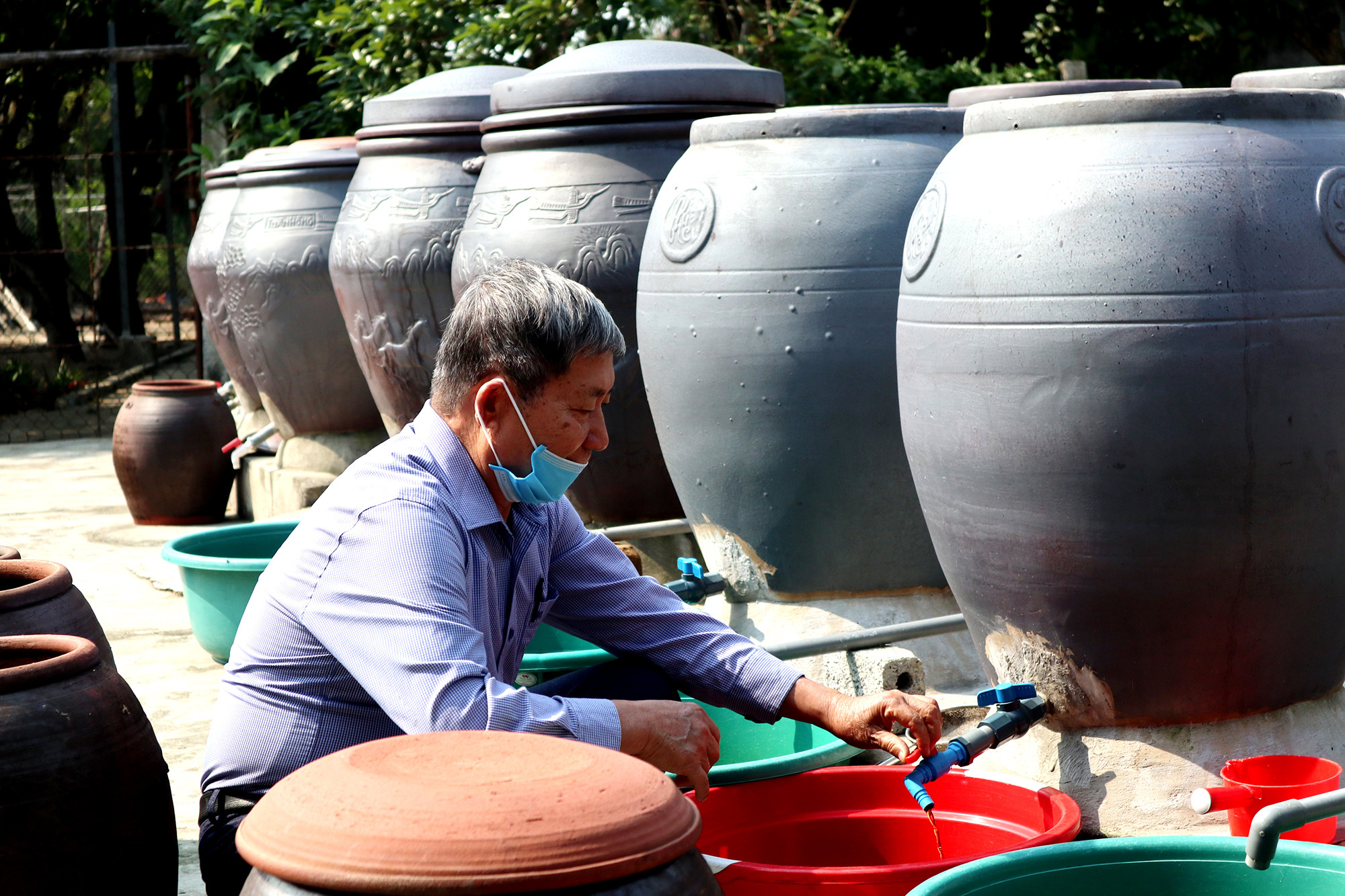 Người dân làng nghề nước mắm Hải Giang 1 chiết, lọc đóng gói sản phẩm nước mắm hạ thổ cung cấp cho thị trường Tết. Ảnh: Thanh Phúc