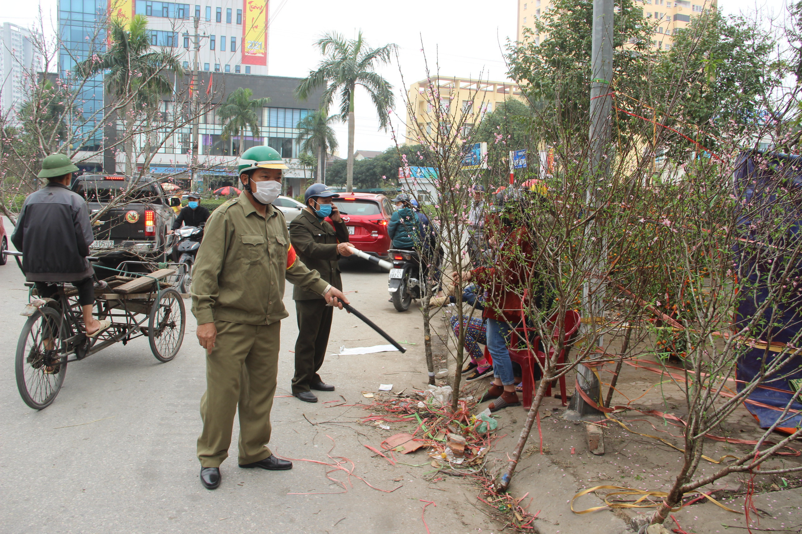 Lực lượng chức năng TP.Vinh xử lý các điểm lấn chiếm vỉa hè, hành lang ATGT để bán cây cảnh Tết. Ảnh: Quang An