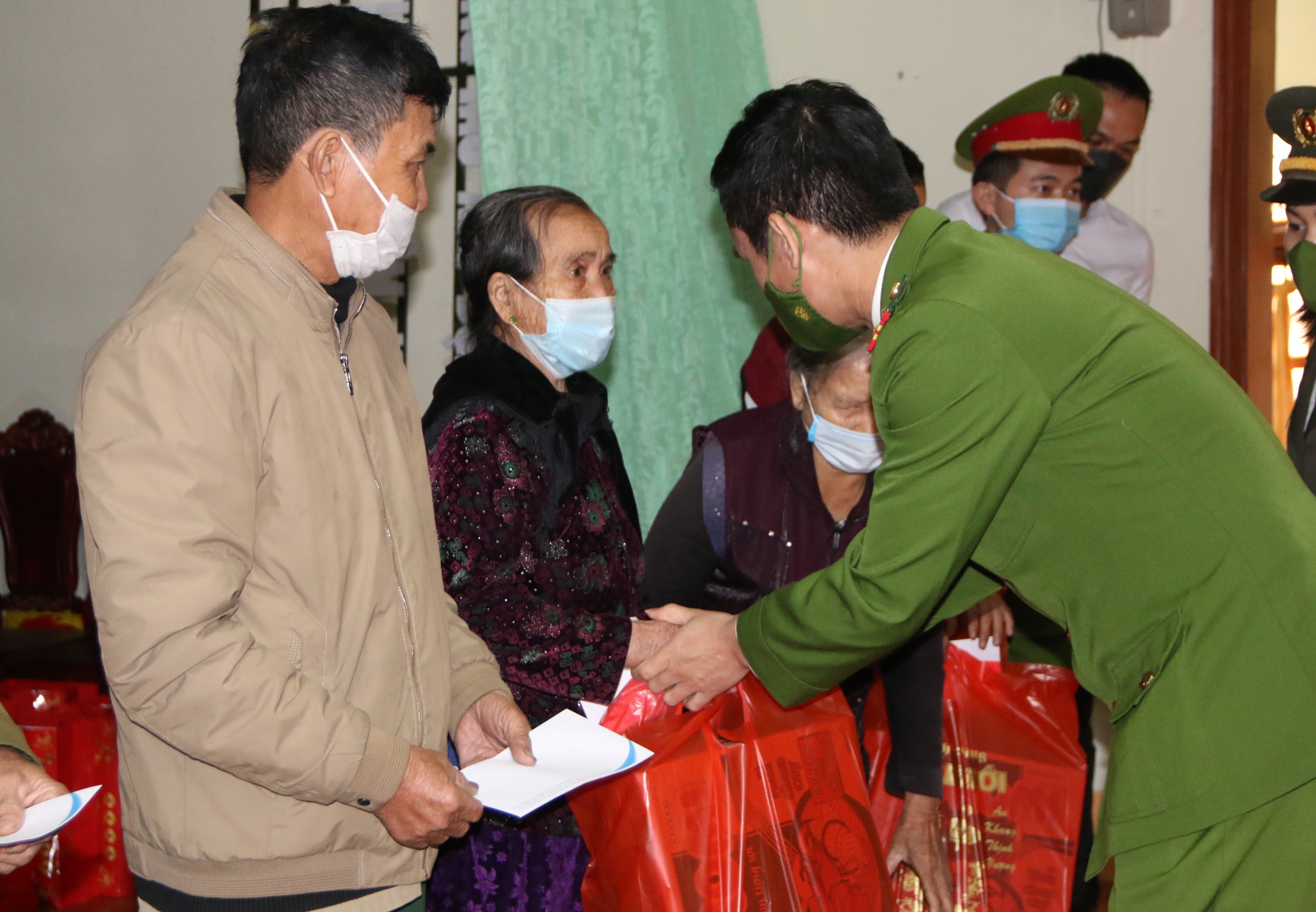 Lãnh đạo Công an huyện Nghi Lộc trao quà cho các hộ nghèo. Ảnh: Tiến Đông 