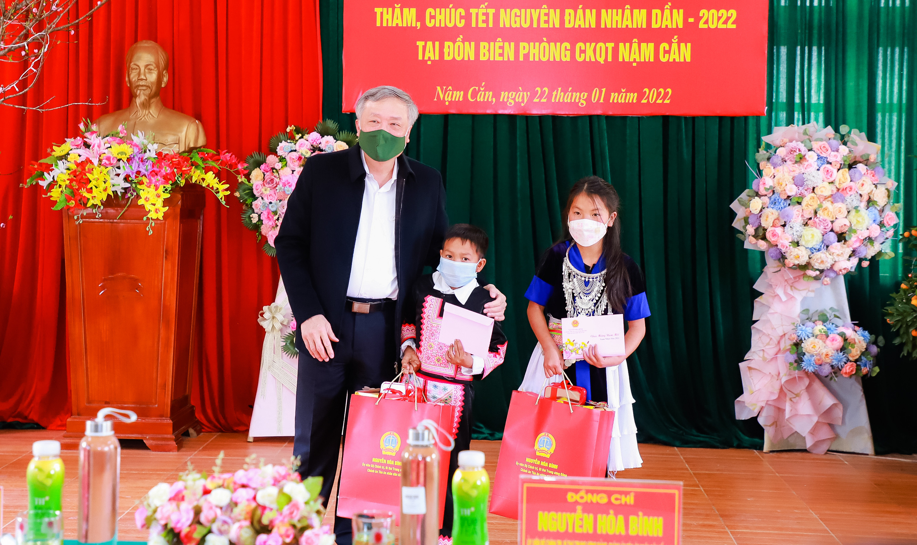 Đồng chí Nguyễn Hòa Bình trao quà cho 2 em nhỏ là con nuôi của Đồn Biên phòng Cửa khẩu quốc tế Nậm Cắn. Ảnh: Thành Duy 