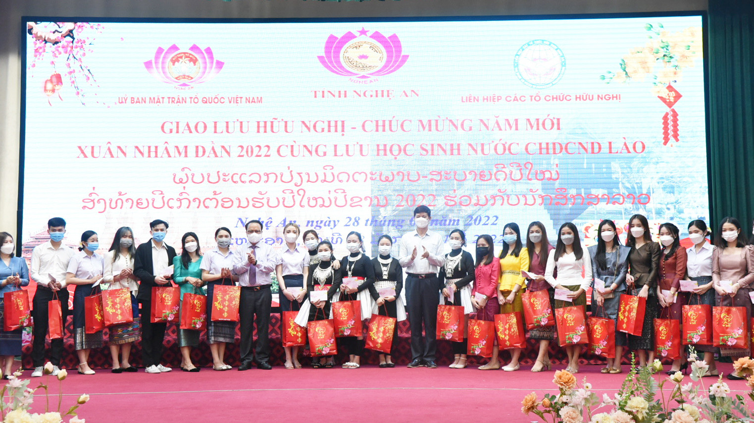 Đồng chí Nguyễn Nam Đình và đồng chí Lê Xuân Đại trao quà Tết cho các em du học sinh Lào. Ảnh: T.G