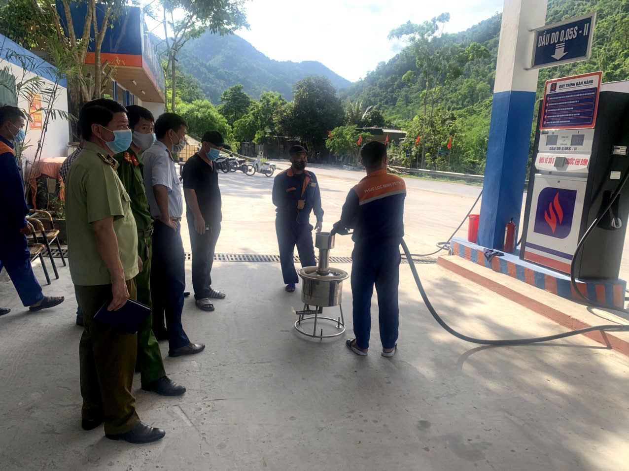 Lực lượng chức năng kiểm tra cột đo bơm xăng tại một cửa hàng kinh doanh xăng dầu tại Con Cuông. Ảnh: Thanh Phúc