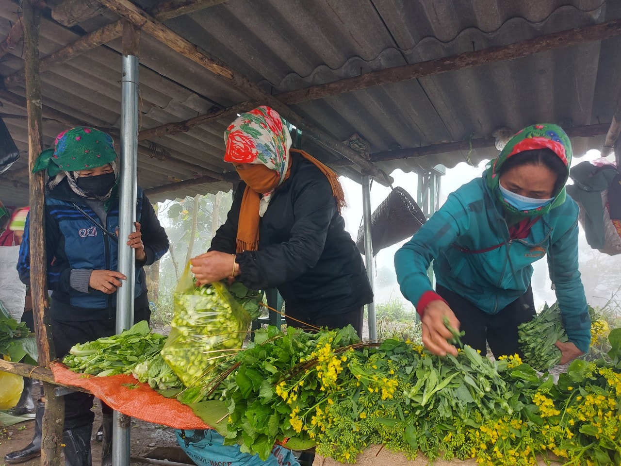 Những phụ nữ bán hàng ở đây phải bịt kín mít để chống chọi với cái rét như cắt da cắt thịt. Ảnh: Tiến Hùng