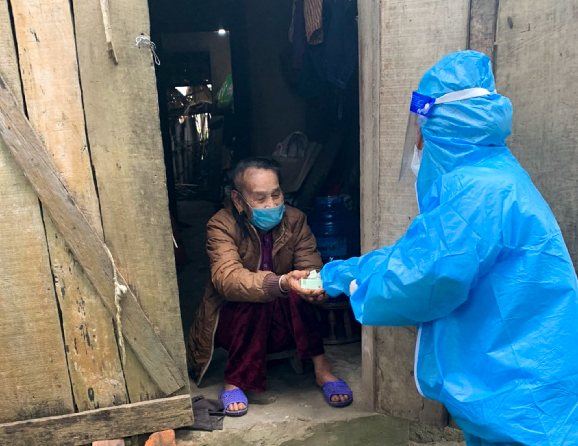 Cán bộ trạm Y tế thị trấn Kim Sơn ủng hộ cho bệnh nhân L.T.P già cả neo đơn ở khối Thái Sơn. Ảnh: Thành Cường