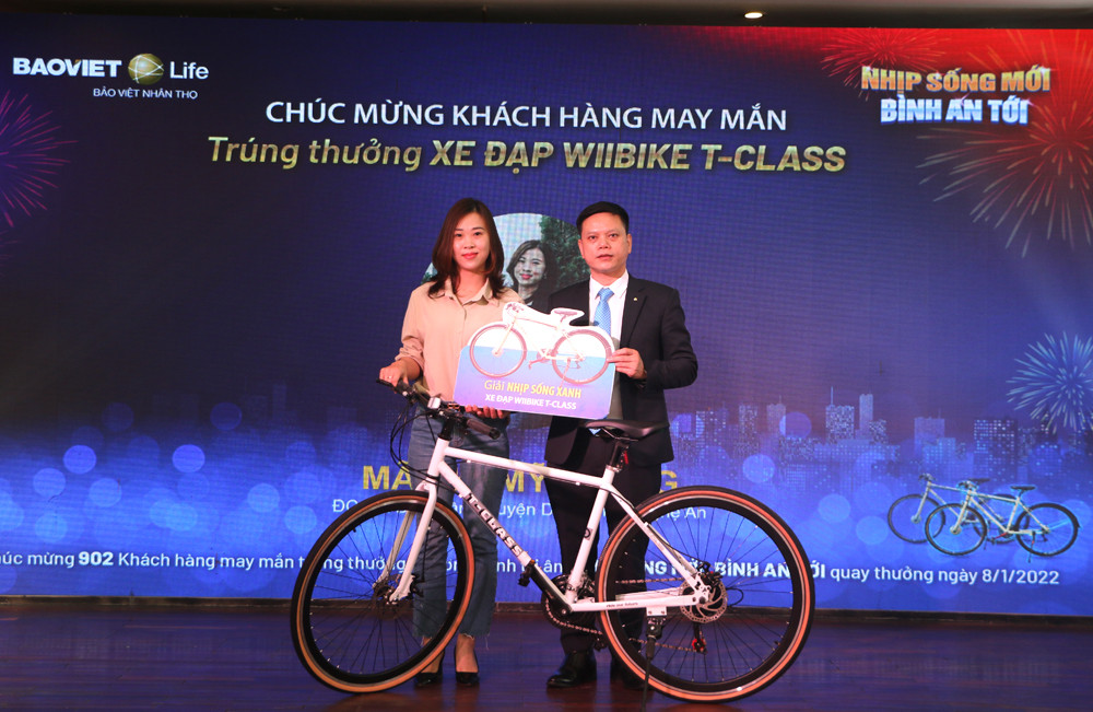 Đại diện Bảo Việt Nhân thọ Bắc Nghệ An trao xe đạp thể thao cho khách hàng may mắn trúng thưởng. Ảnh: Nguyễn Hải