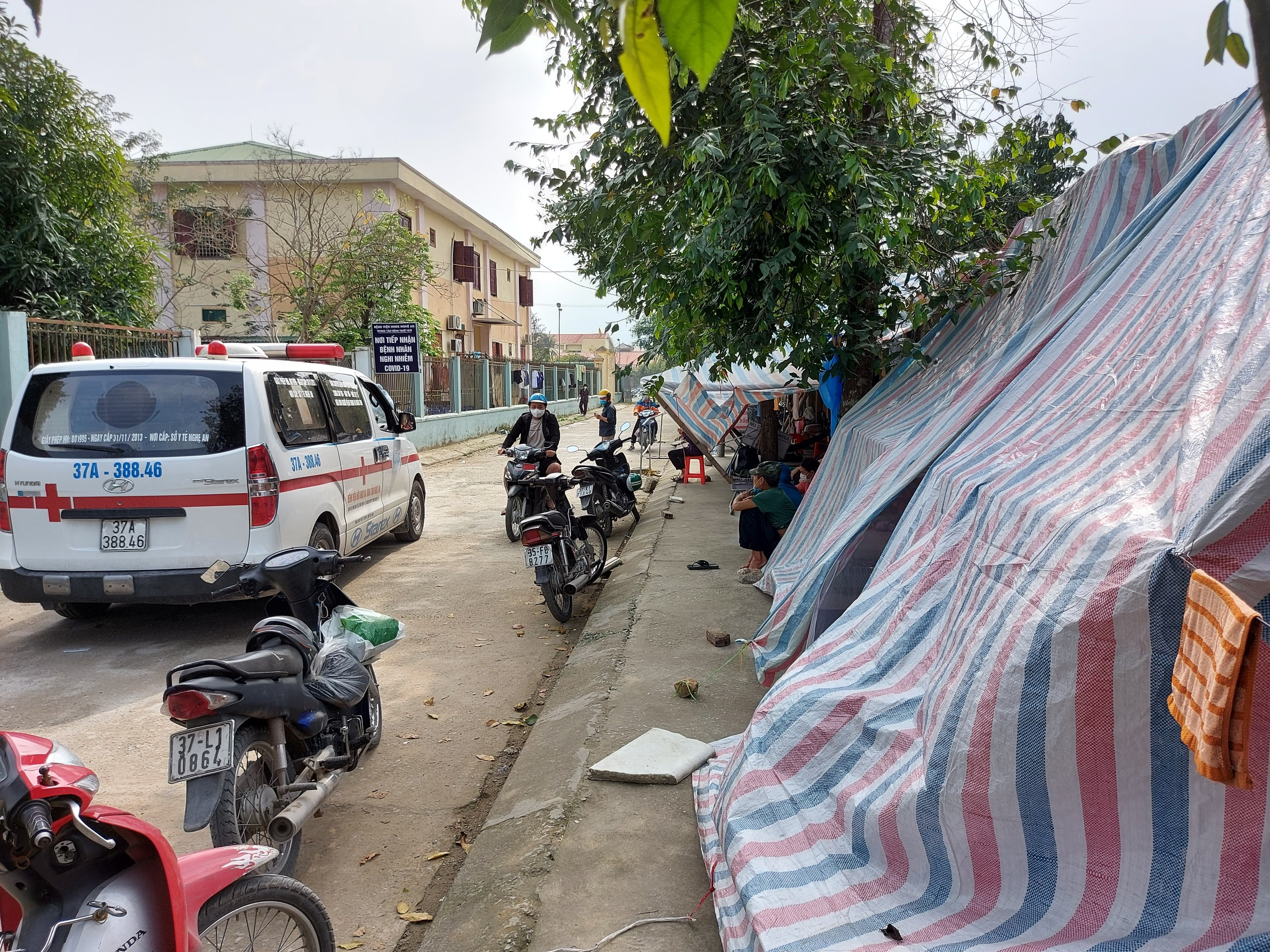 Có những ngày, hàng trăm người vật vã ngủ dọc lề đường trước cổng Trung tâm bệnh nhiệt đới. Ảnh: Tiến Hùng