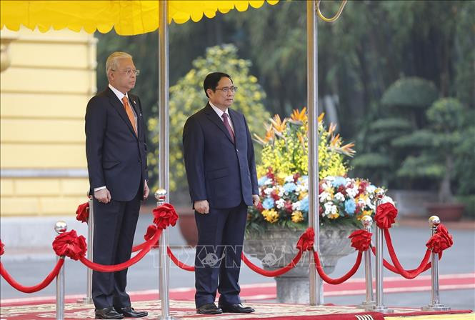 Thủ tướng Phạm Minh Chính và Thủ tướng Malaysia Dato’ Sri Ismail Sabri bin Yaakob nghe quân nhạc cử Quốc thiều hai nước. Ảnh: Dương Giang/TTXVN