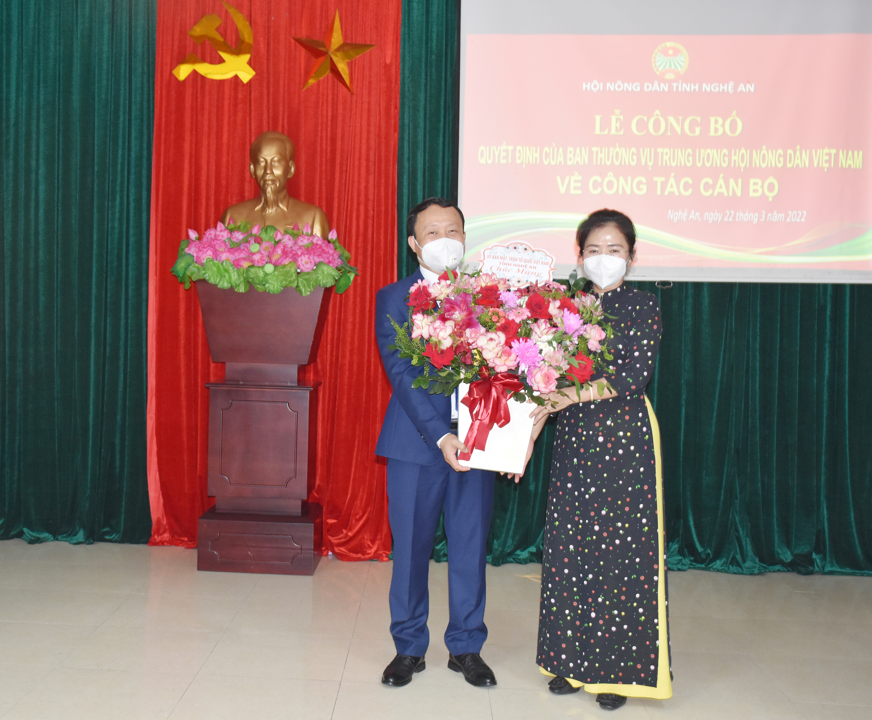 Đồng chí Võ Thị Minh Sinh - Chủ tịch Ủy ban MTTQ tỉnh Nghệ An tặng hoa chúc mừng đồng chí Võ Văn Phong. Ảnh: Thanh Lê