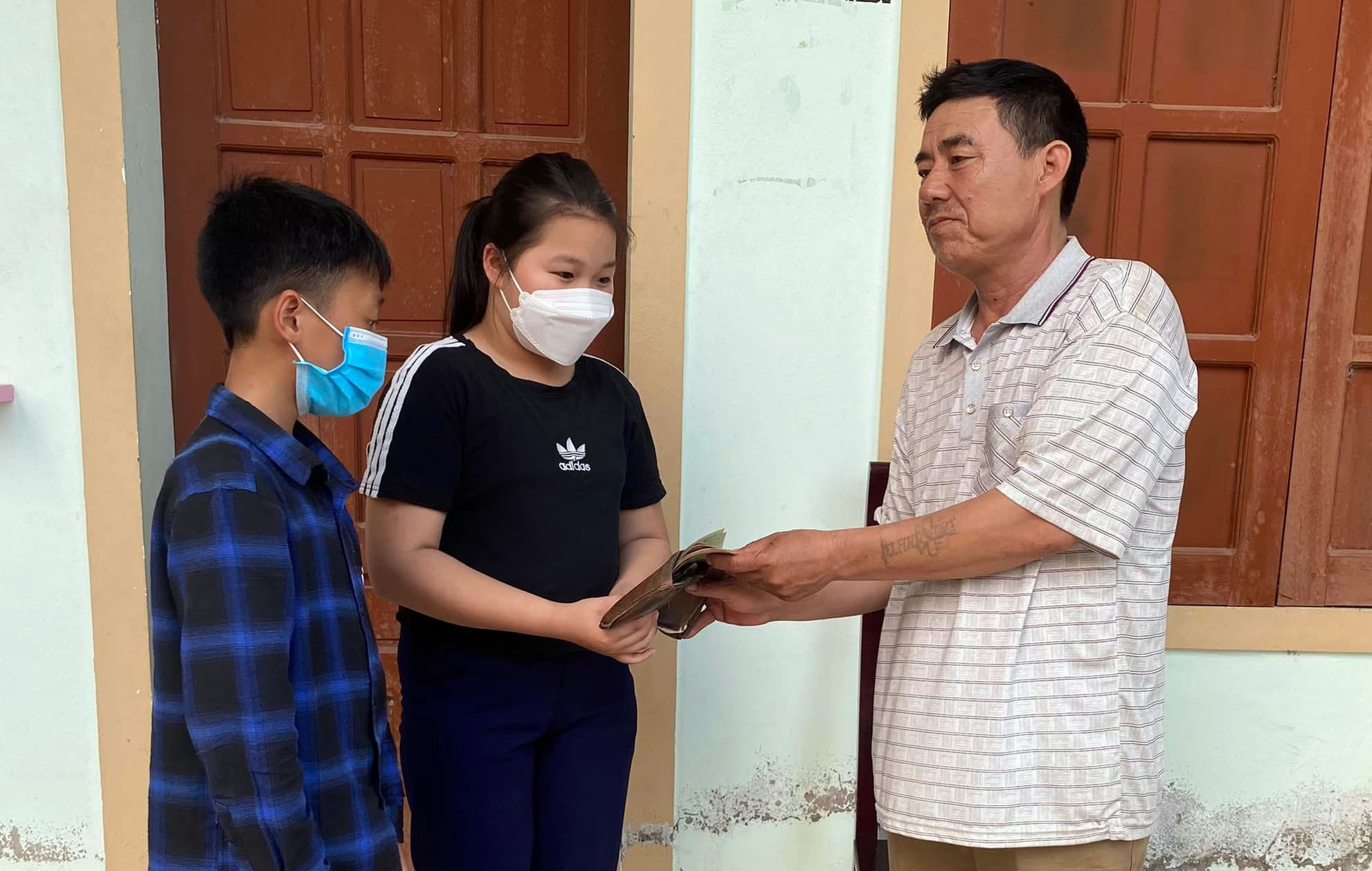 Hai học sinh Trường THCS Nghi Kiều trả tài sản cho người bị mất. Ảnh: CA Nghi Kiều