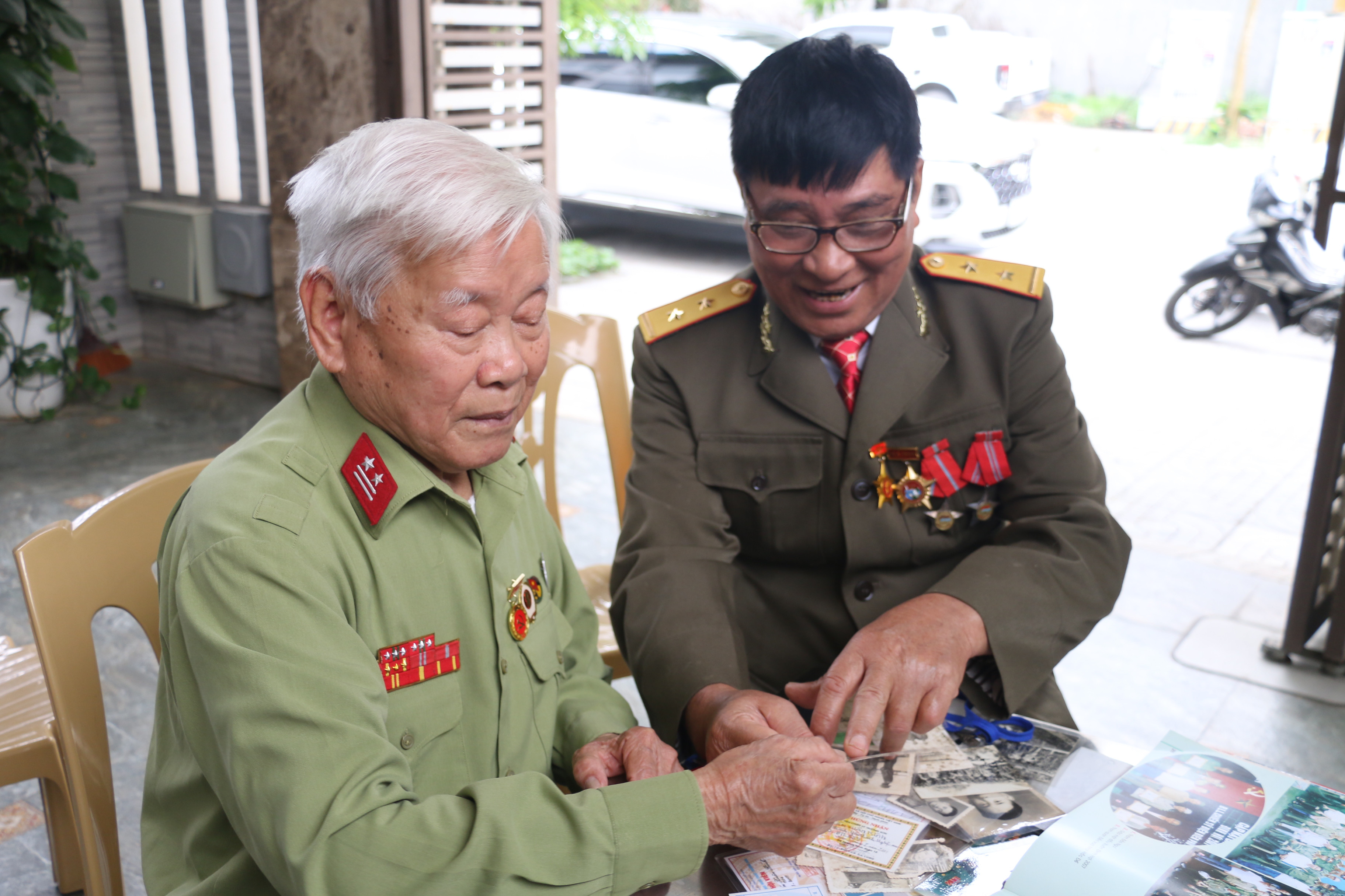 Cựu chiến binh Trần Xuân Kình đang xem lại tài liệu cùng với các đồng đội cũ