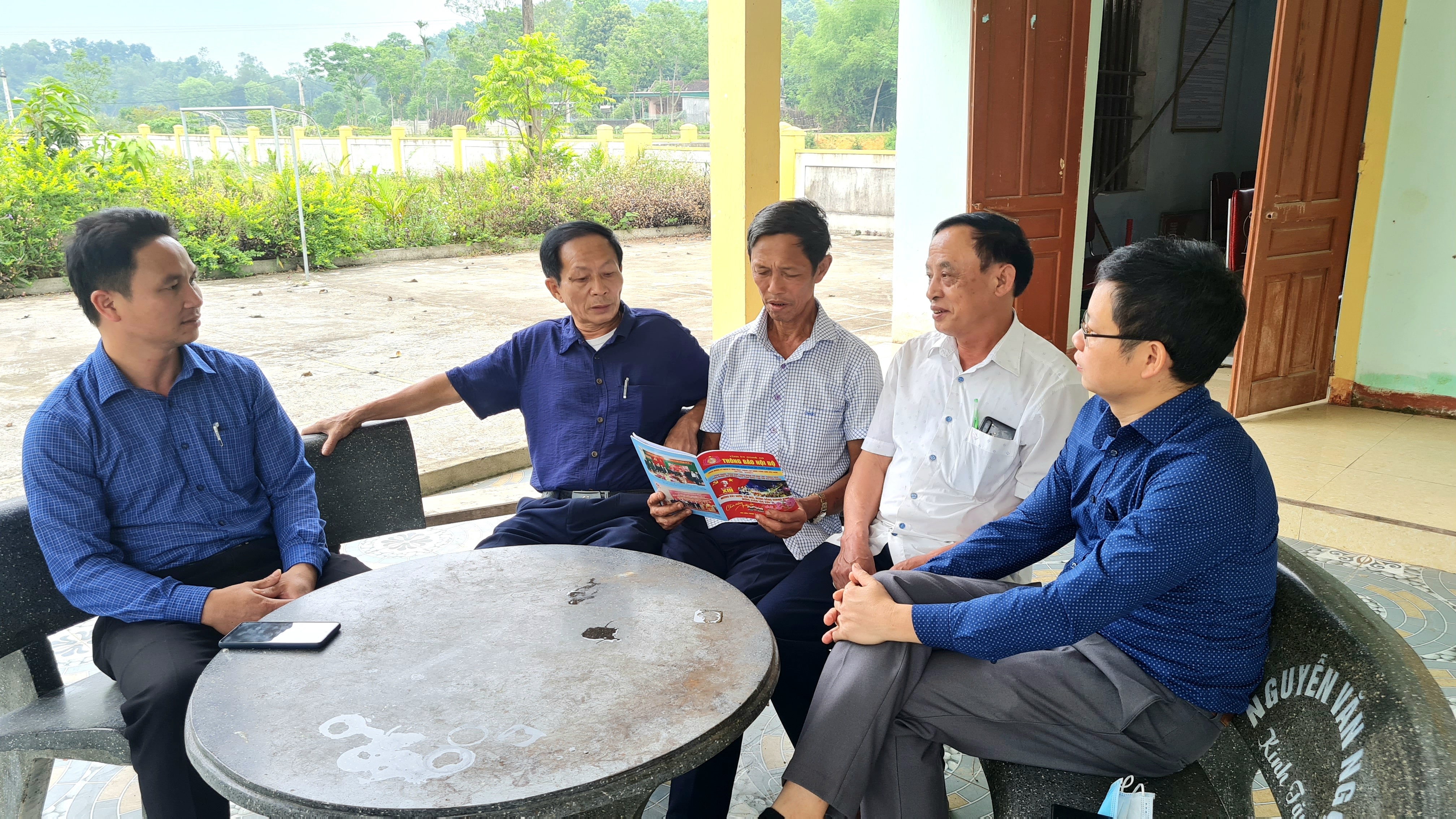 Cán bộ Huyện ủy Thanh Chương trao đổi với Ban cán sự thôn 4 về hiệu quả triển khai Tổ tự quản kiểu mẫu ở cơ sở. Ảnh: HT