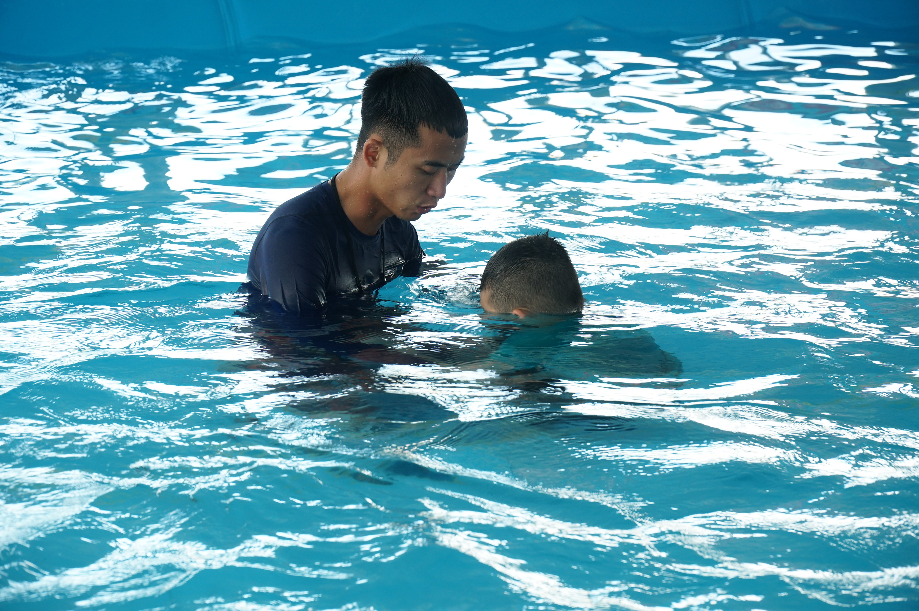 Theo thầy giáo Nguyễn Văn Thắng thì dạy bơi ở lứa tuổi nào cũng bắt đầu từ những kỹ năng đơn giản như tập nín thở trên không, tập nín thở dưới nước. Dạy bơi ở tiểu học sẽ khó khăn hơn vì các em chưa biết tư duy. Vì thế, một lớp học bơi chỉ dạy từ 7 - 10 em sẽ phát huy được hiệu quả. Ảnh: MH