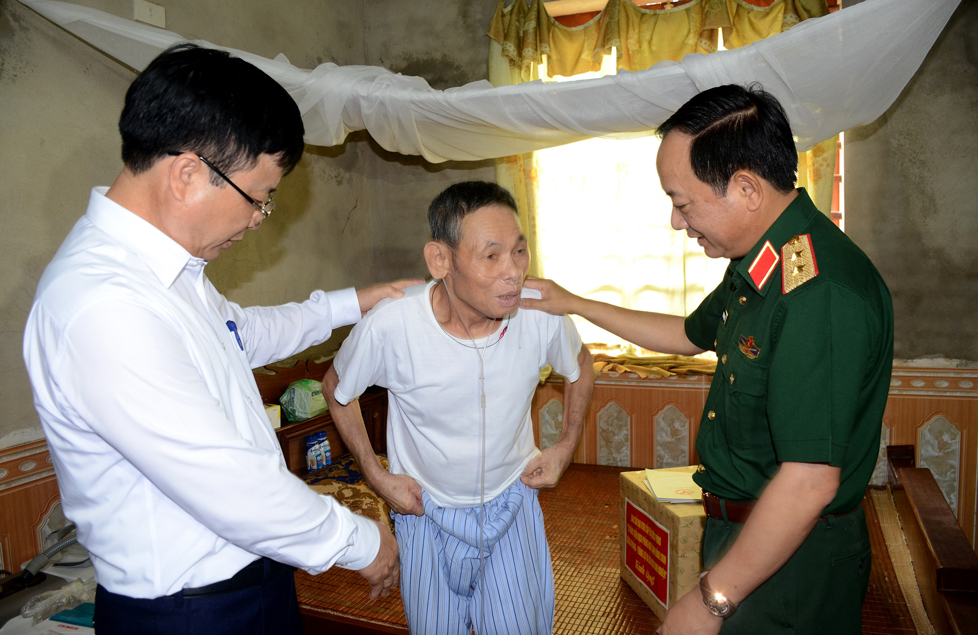 Lãnh đạo Tổng cục Chính trị Bộ Quốc phòng và UBND tỉnh Nghệ An thăm hỏi, động viên thương binh Nguyễn Văn Duyệt. Ảnh: Thành Chung