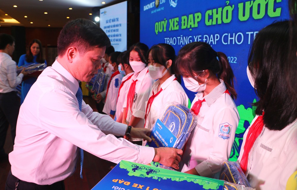 Giám đốc Bảo Việt Nhân thọ Bắc Nghệ An Hoàng Công Sáng và đại diện Quỹ Bảo trợ trẻ em trao ba lo cho các cháu học sinh nghèo. Ảnh: Nguyễn Hải