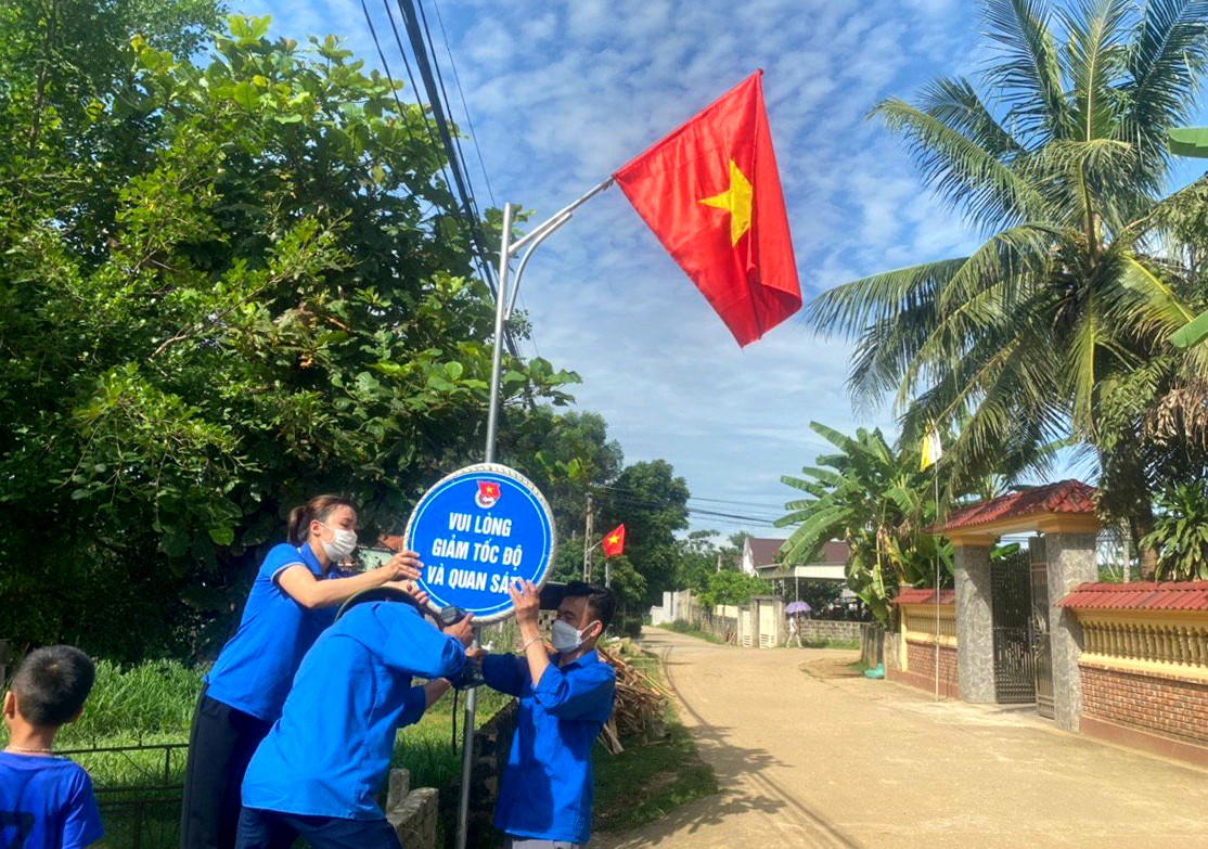 bna_ĐTN xã Nghĩa An treo cờ, biển đoạn qua xóm Đồng Tâm A.jpg