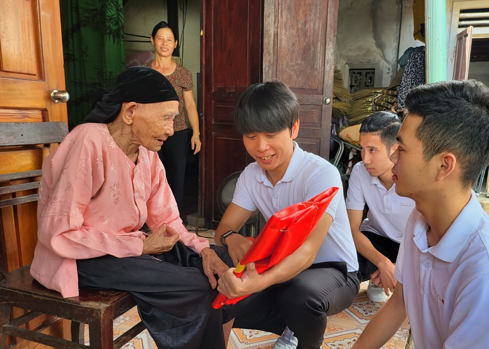 Lê Quyết Thắng và các bạn về Thanh Chương trao ảnh liệt sĩ Nguyễn Văn Đồng cho mẹ Nguyễn Thị Ba. Ảnh: Tiến Đông