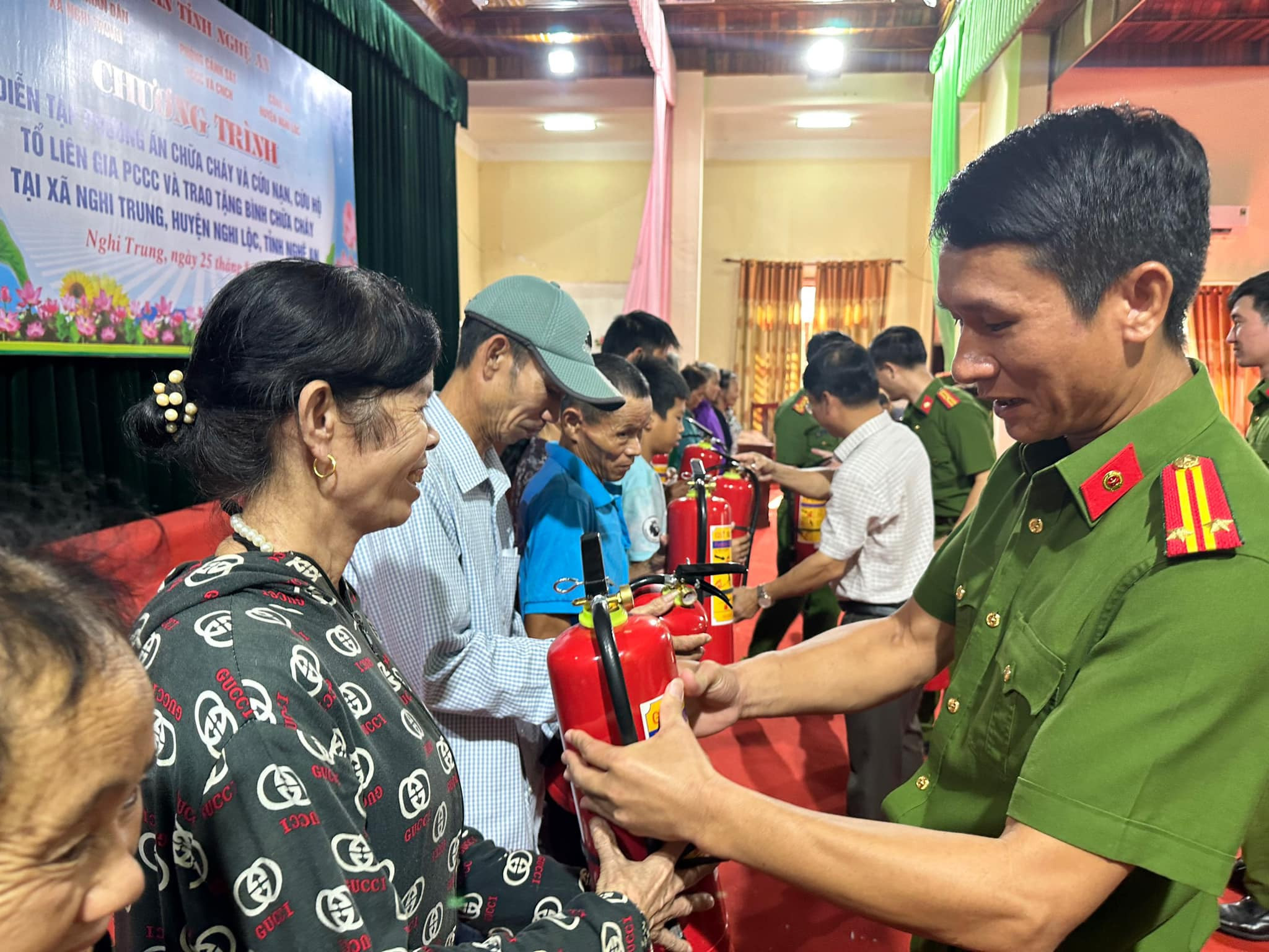bna_Trưởng Công an huyện Nghi Lộc trao tặng bình chữa cháy cho các hộ gia đình trên địa bàn xã Nghi Trung. ảnh pv.jpg