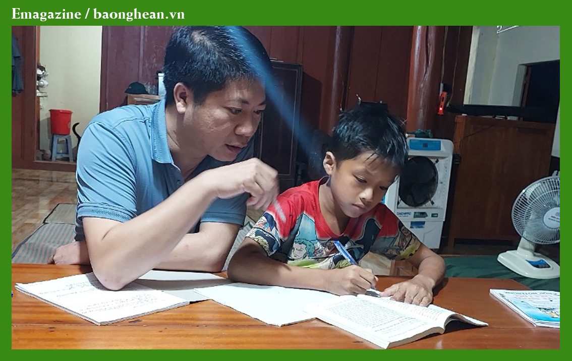 Cán bộ tổ công tác bản Lốc, đồn Biên phòng Thông Thụ (Quế Phong) hướng dẫn con nuôi là em Ngân Trần Khanh học bài. Ảnh: P.V