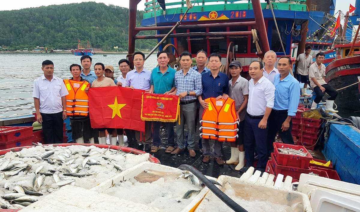 Lãnh đạo phường Nghi Thủy tặng Cờ thi đua cho đội tàu có sản lượng đánh bắt tốt. Ảnh tư liệu: CSCC
