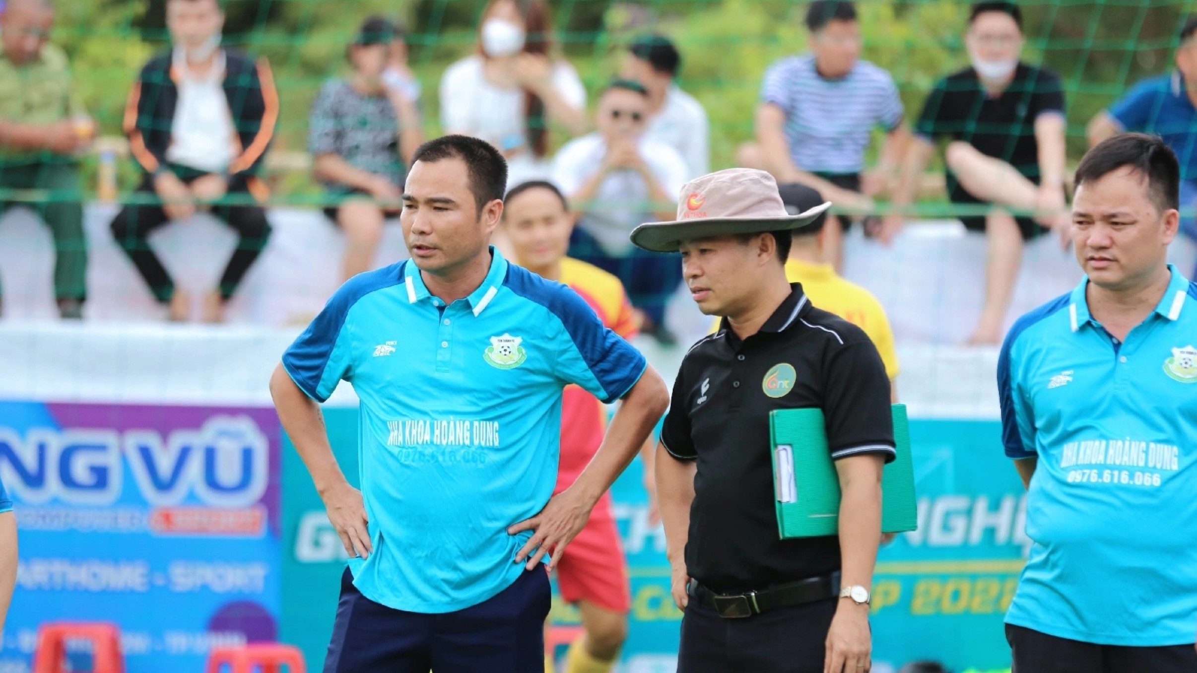bna_Trần Minh Châu (ngoài cùng bên trái) theo dõi các học trò tại một giải bóng đá ở huyện.jpg