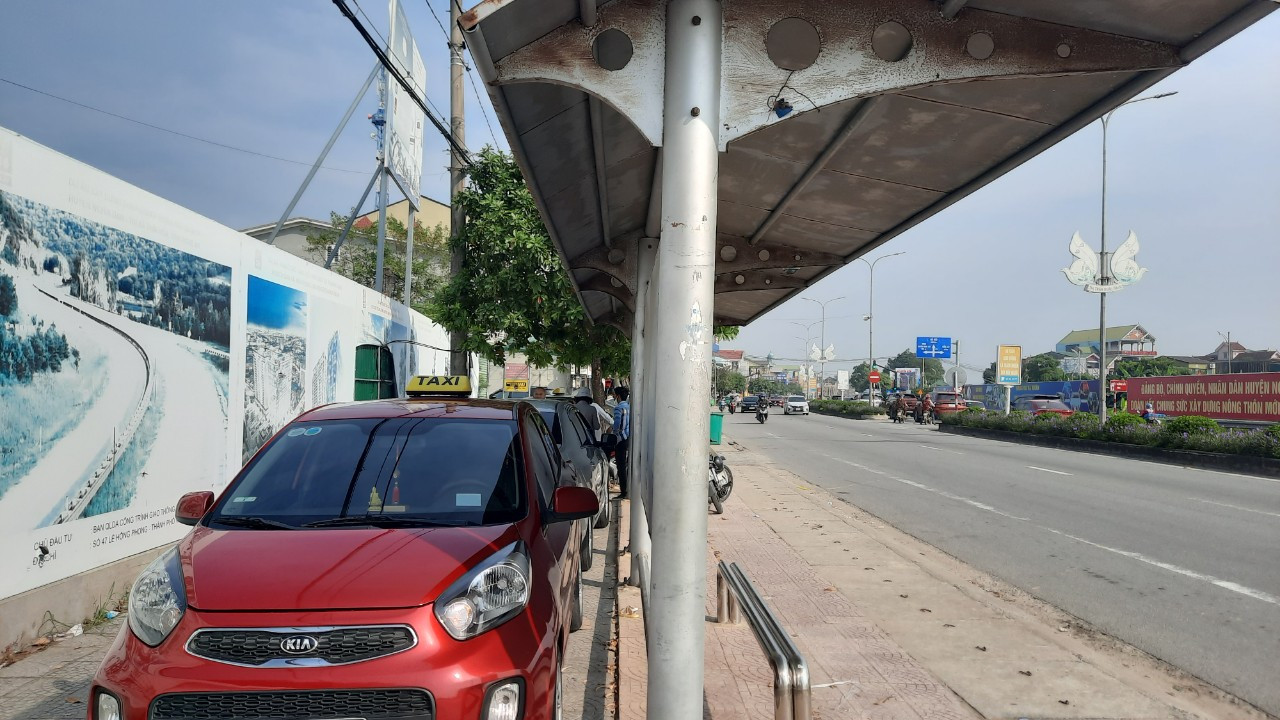 bna_Taxi dù chờ đón khách tại điểm xe buýt cạnh phòng giao dịch Ngân hàng Agribank thị trấn Quán Hành, huyện Nghi Lộc. ảnh pv.jpg