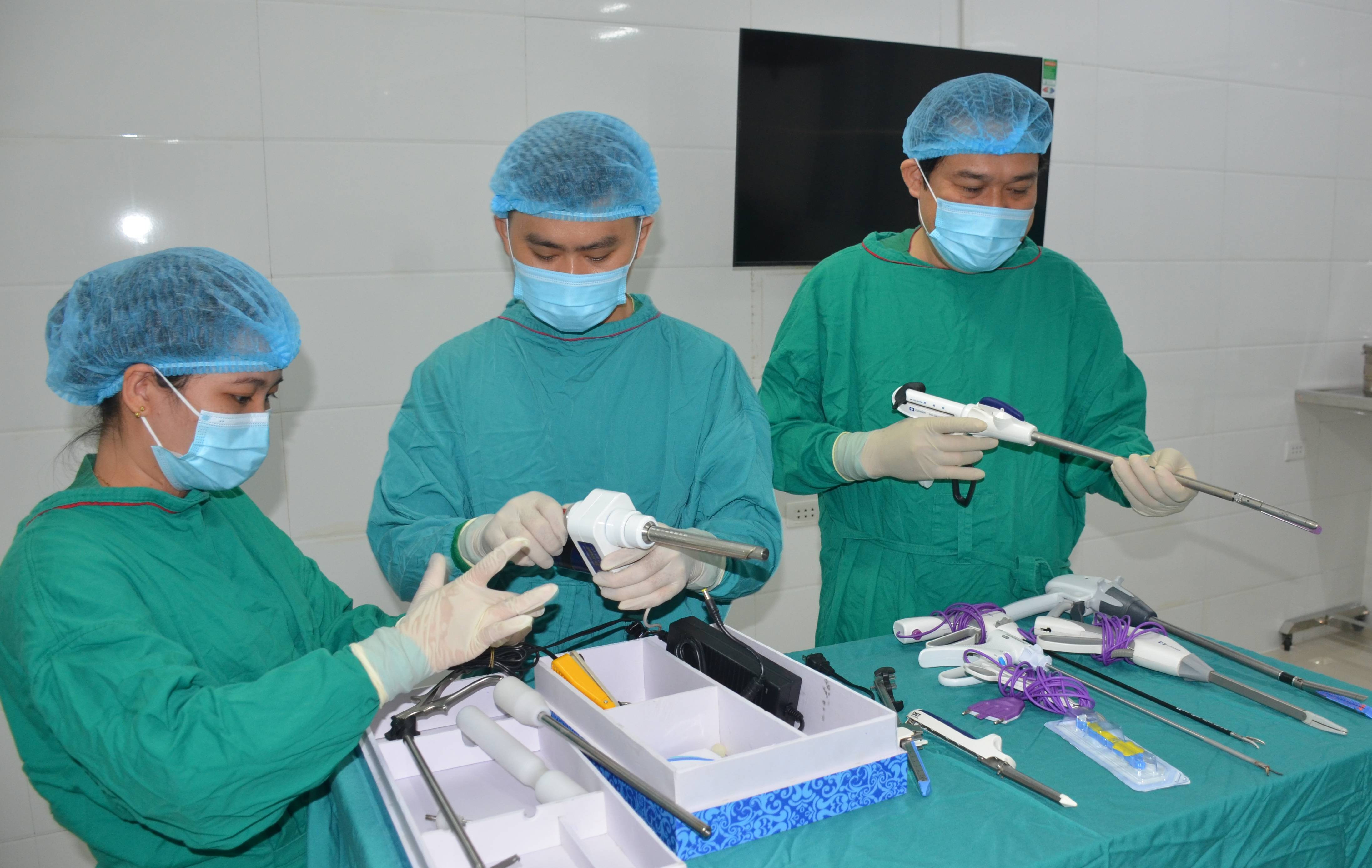 Bác sĩ Nguyễn Văn Khanh và các nhân viên phòng mổ chuẩn bị dụng cụ cho ca phẫu thuật nội soi cắt tử cung bán phần. Ảnh Thành Chung.jpg
