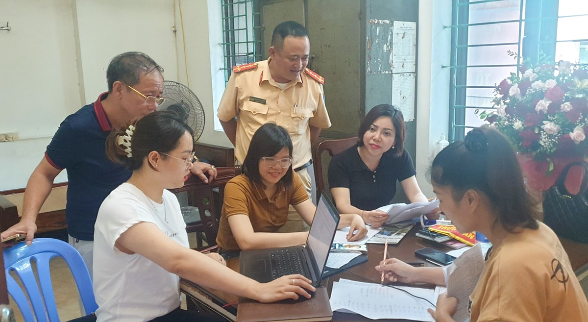 Các lực lượng chức năng hướng dẫn người dân phường Hồng Sơn (TP. Vinh) cài đặt định danh điện tử. Ảnh: Thanh Lê