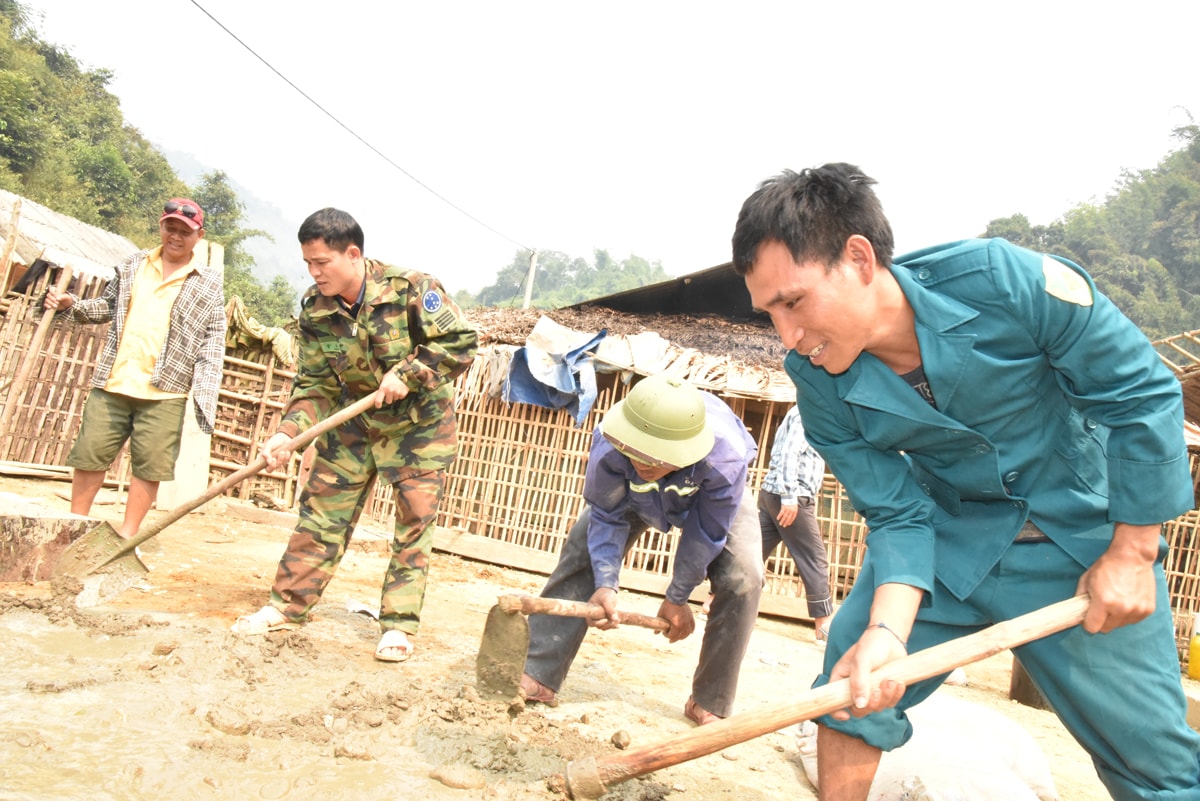 Cán bộ huyện Kỳ Sơn và xã Bảo Thắng giúp nhân dân bản Thà Lạng làm nhà ở. Ảnh: H.T