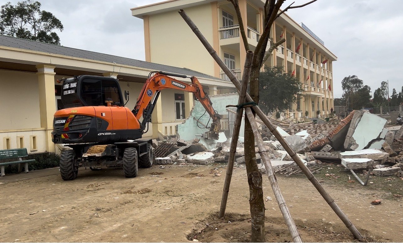 Chính quyền địa phương huy động lực lượng, phương tiện tháo dỡ di dời ngôi nhà của bà Đặng Thị Nông ra khỏi khuôn viên Trường Tiểu học Quỳnh Lập A. Ảnh: CSCC