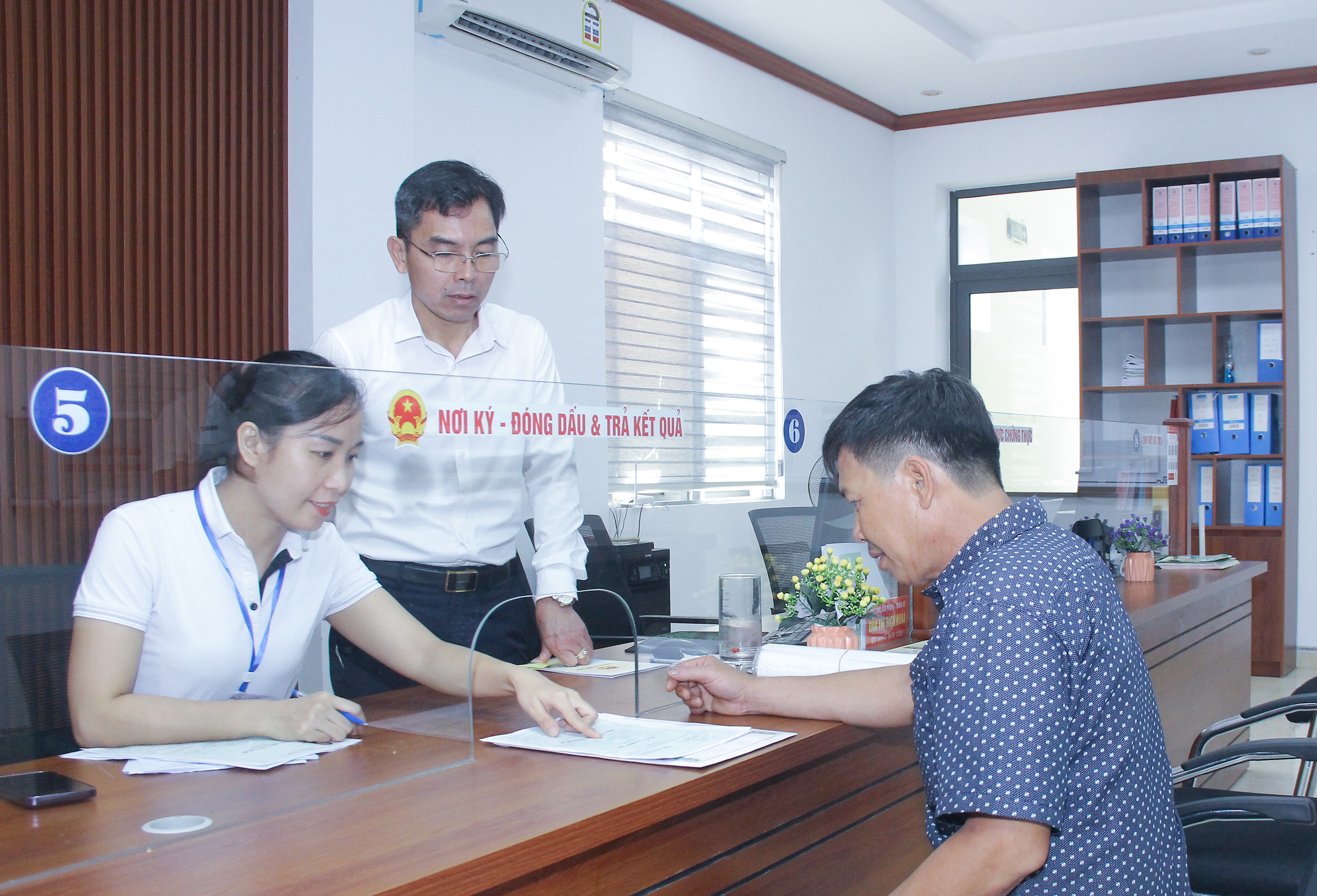 bna_ Cán bộ, công chức phường Vinh Tân giải quyết thủ tục hành chính cho người dân. Ảnh- MaiHoa.jpg