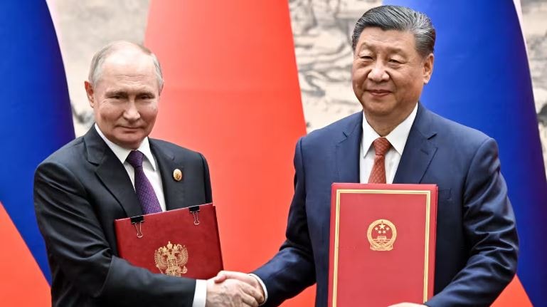 Tổng thống Nga Vladimir Putin và Chủ tịch Trung Quốc Tập Cận Bình trao đổi tài liệu song phương trong cuộc gặp ở Bắc Kinh ngày 16/5.