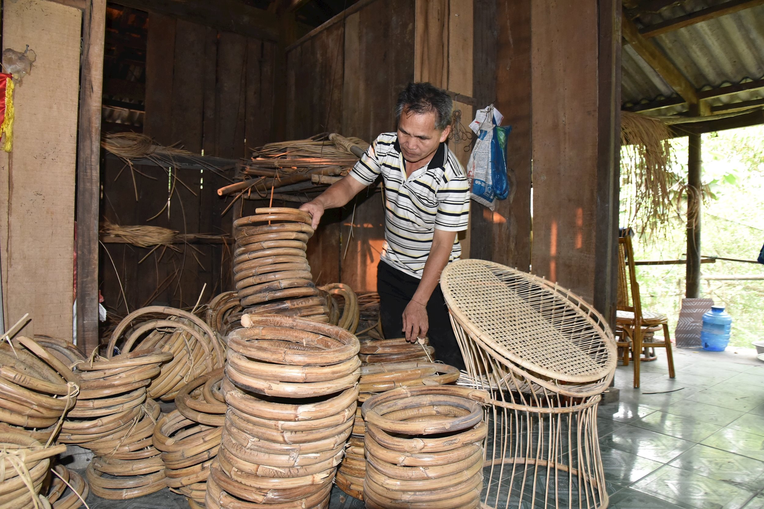 Ông Kha Văn Thương bên các sản phẩm mây tre đan.