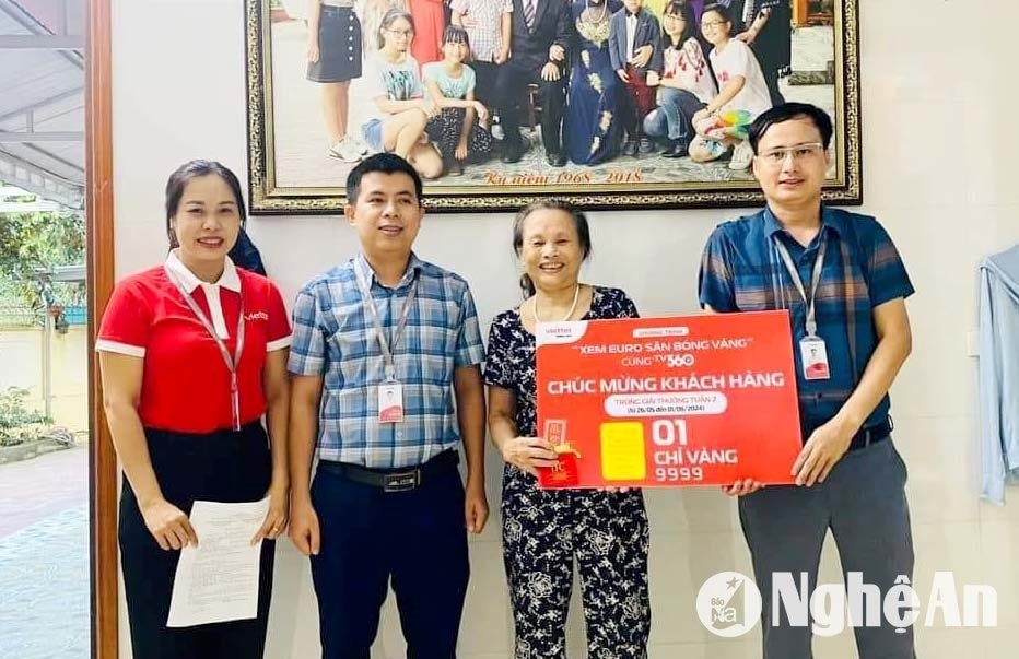 Đại diện gia đình ông Nguyễn Đình Hạ - khối 3, thị trấn Thanh Chương nhận giải thưởng chương trình. Ảnh: PV