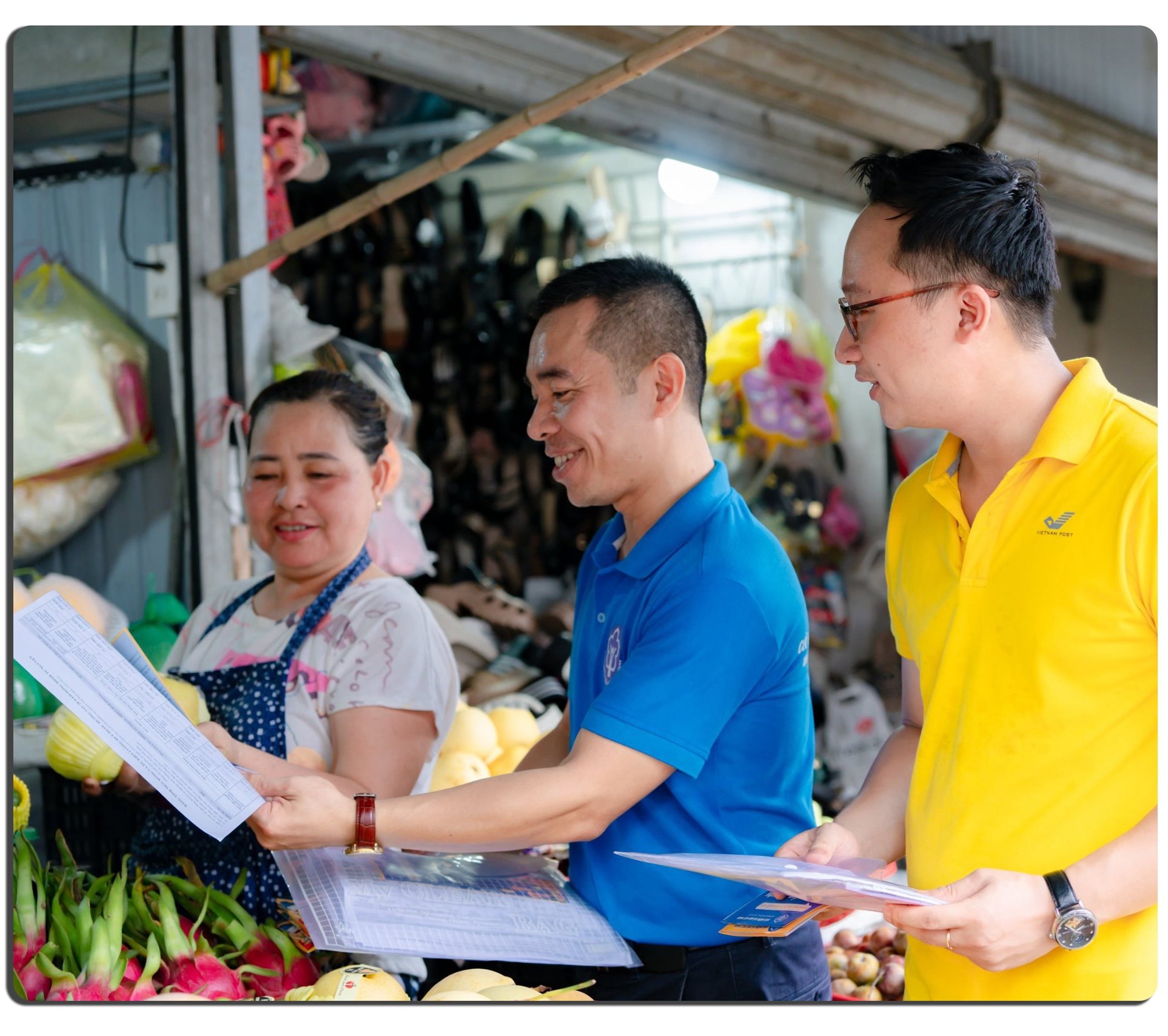 Cán bộ BHXH Nghệ An phối hợp Bưu điện tỉnh tuyên truyền chính sách BHXH, BHYT cho người dân tại chợ quán Lau (TP Vinh). Ảnh Nguyễn Đạo 4 b