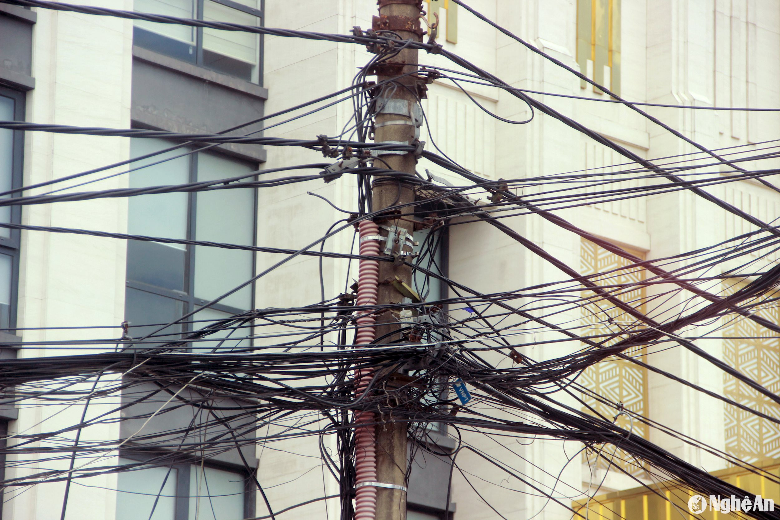 Hơn 100 cột điện trên tuyến đường này đã có từ lâu đời, dây mạng viễn thông quấn chằng chịt. Ảnh: Quang An