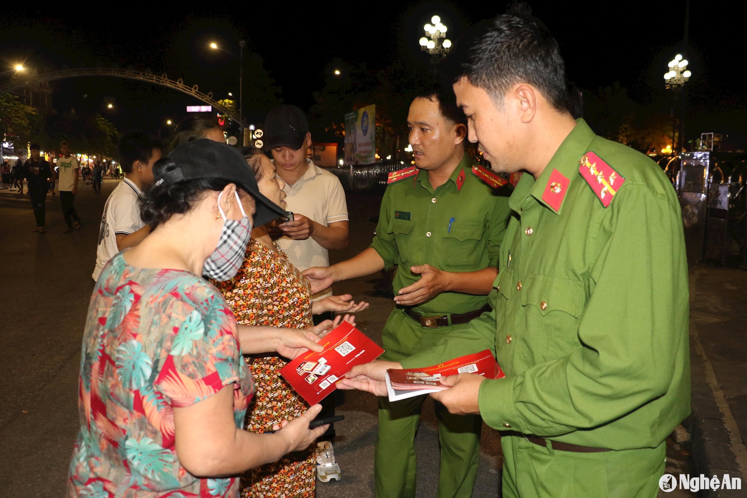 Cán bộ Phòng Cảnh sát Quản lý hành chính về trật tự xã hội Công an tỉnh phát tờ rơi, hướng dẫn người dân về quy trình đăng ký cài đặt định danh điện tử trên điện thoại. ảnh pv