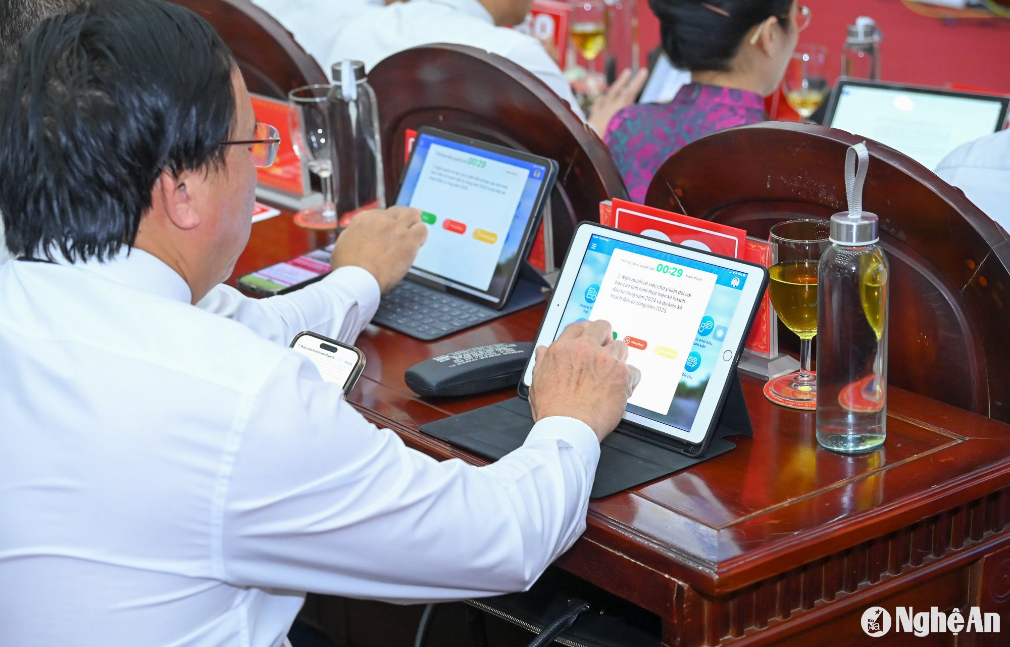 Các đại biểu HĐND tỉnh biểu quyết theo hình thức điện tử qua ứng dụng trên máy tính bảng. Ảnh: Thành Cường