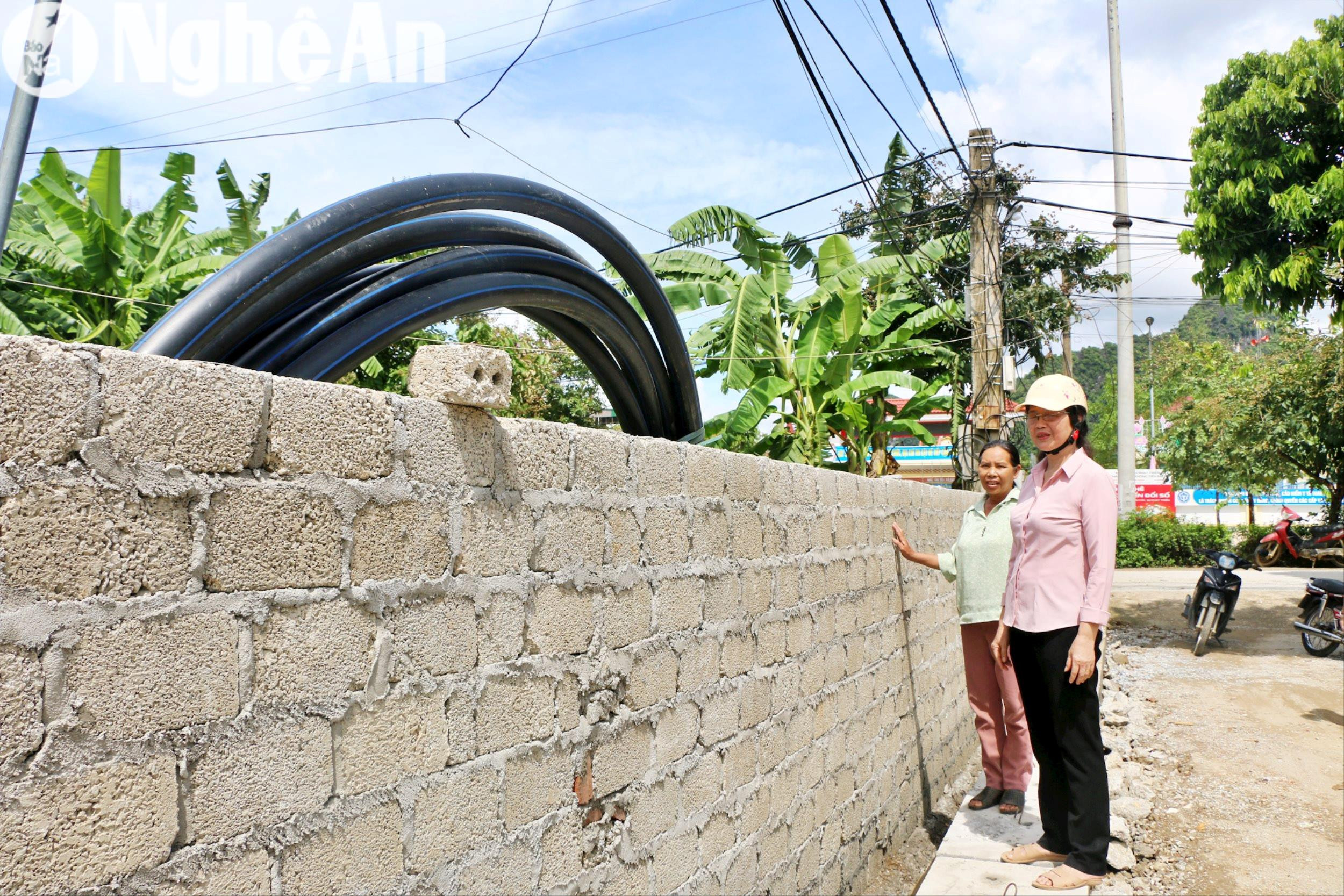 Gia đình chị Nguyễn Thị Viện ( áo xanh) được chính quyền hỗ trợ xây lại bờ rào sau khi hiến đất. Ảnh: Khánh Ly