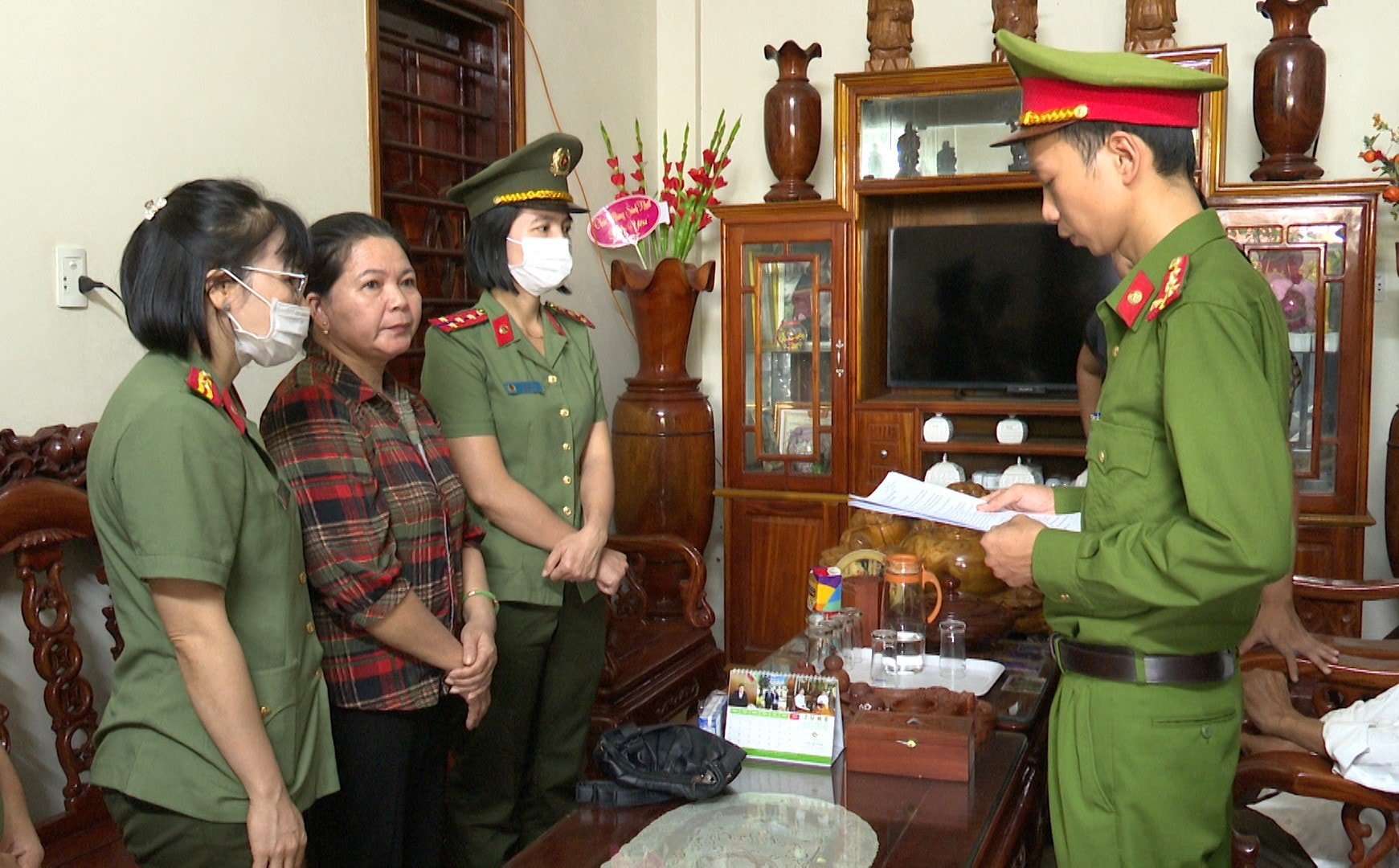 Công an huyện Hải Lăng đọc lệnh bắt, tạm giam đối với bị can Lê Thị Hương tại nhà riêng. (Nguồn: Báo Quảng Trị)