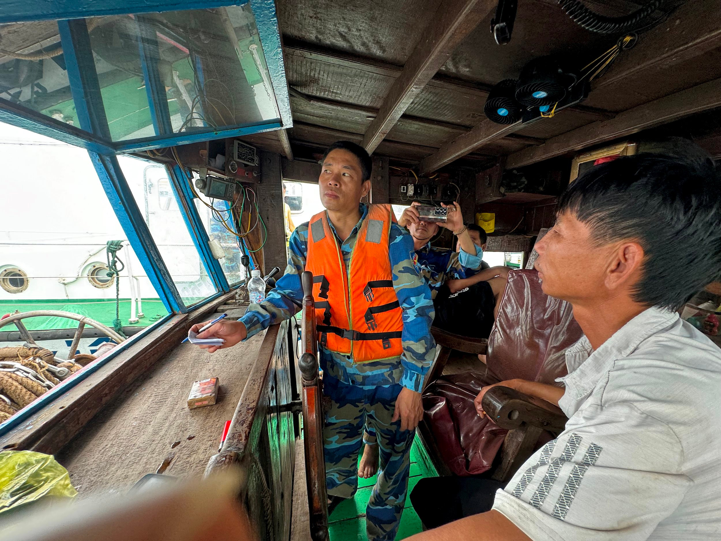 Lục lượng kiểm ngư thuộc đoàn liên ngành tỉnh kiểm tra thiết bị giám sát hành trình trên tàu cá đang đánh bắt trên vùng lộng. Ảnh Nguyễn Hải